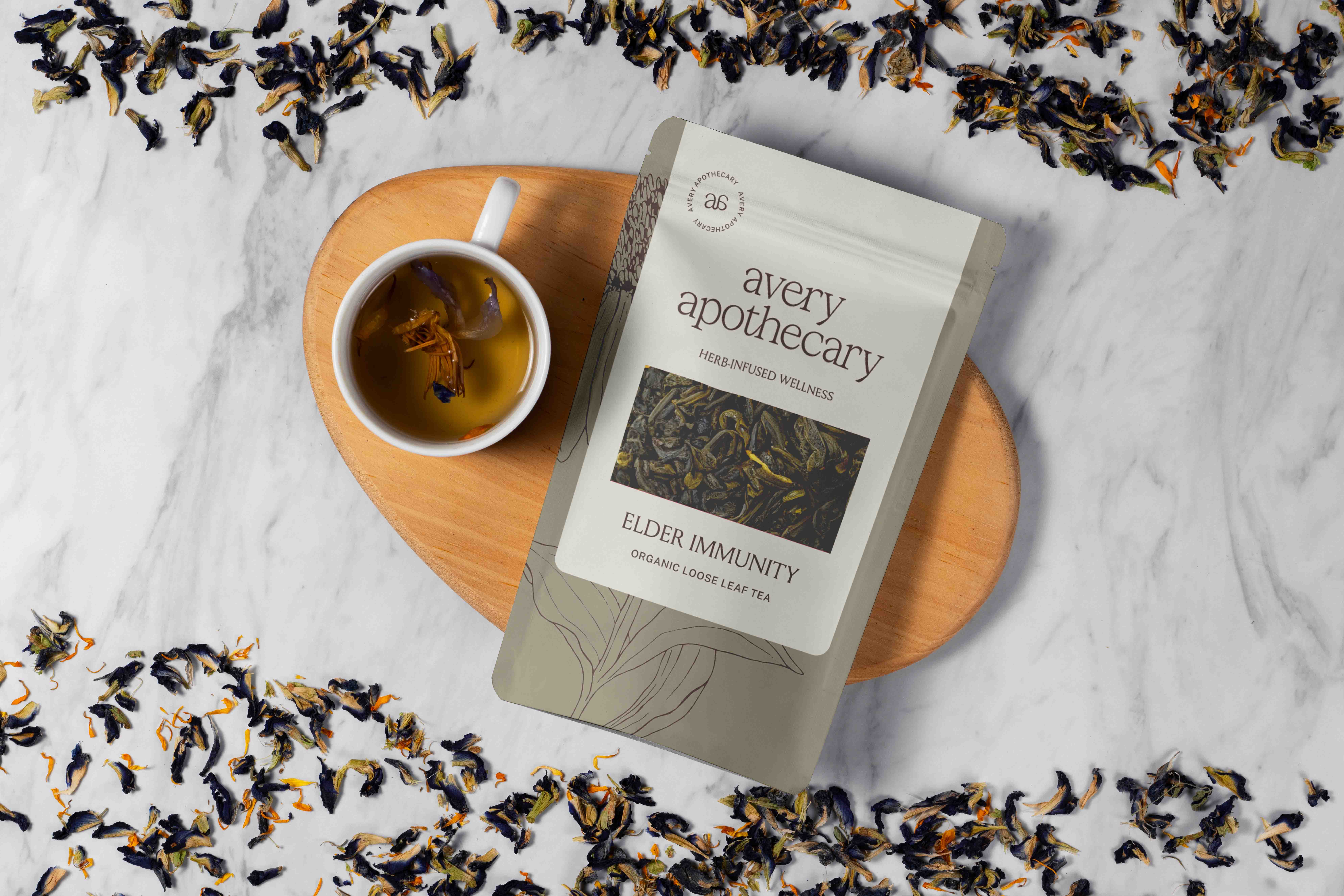 A tea package beside a cup of brewed tea on a marble surface.