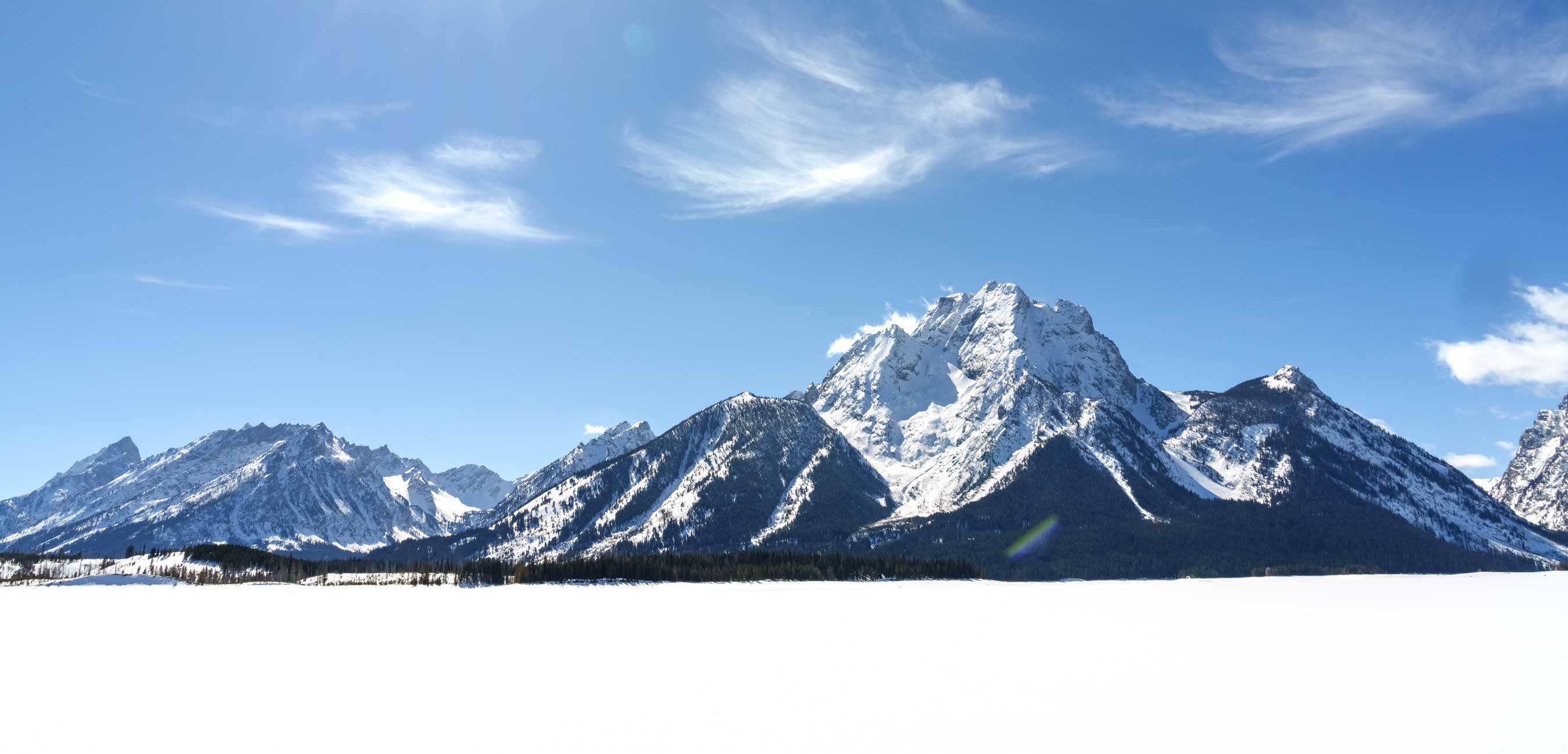 Snow-covered mountains under a clear blue sky.