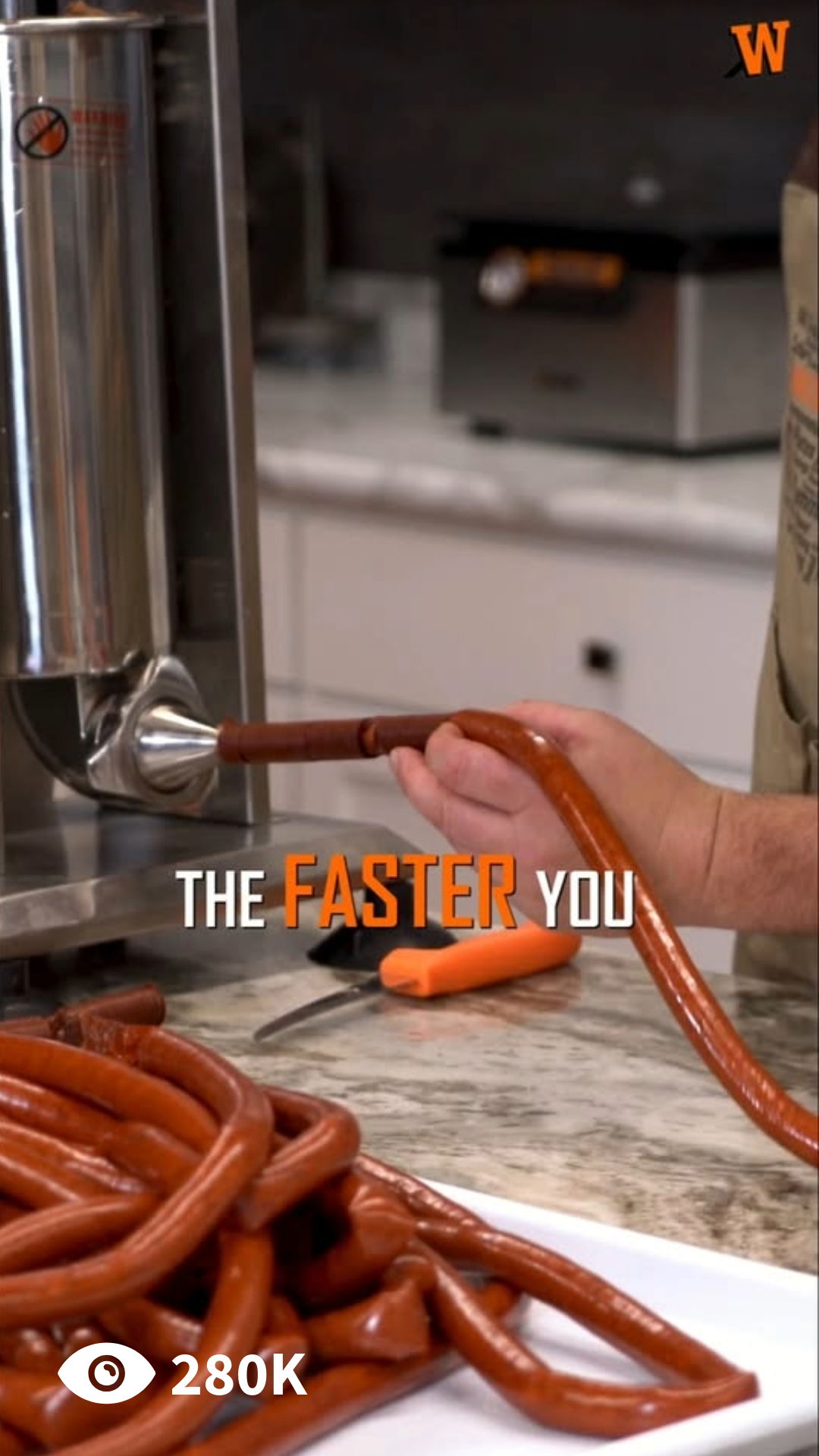 A person using a sausage stuffer with sausages on a counter.