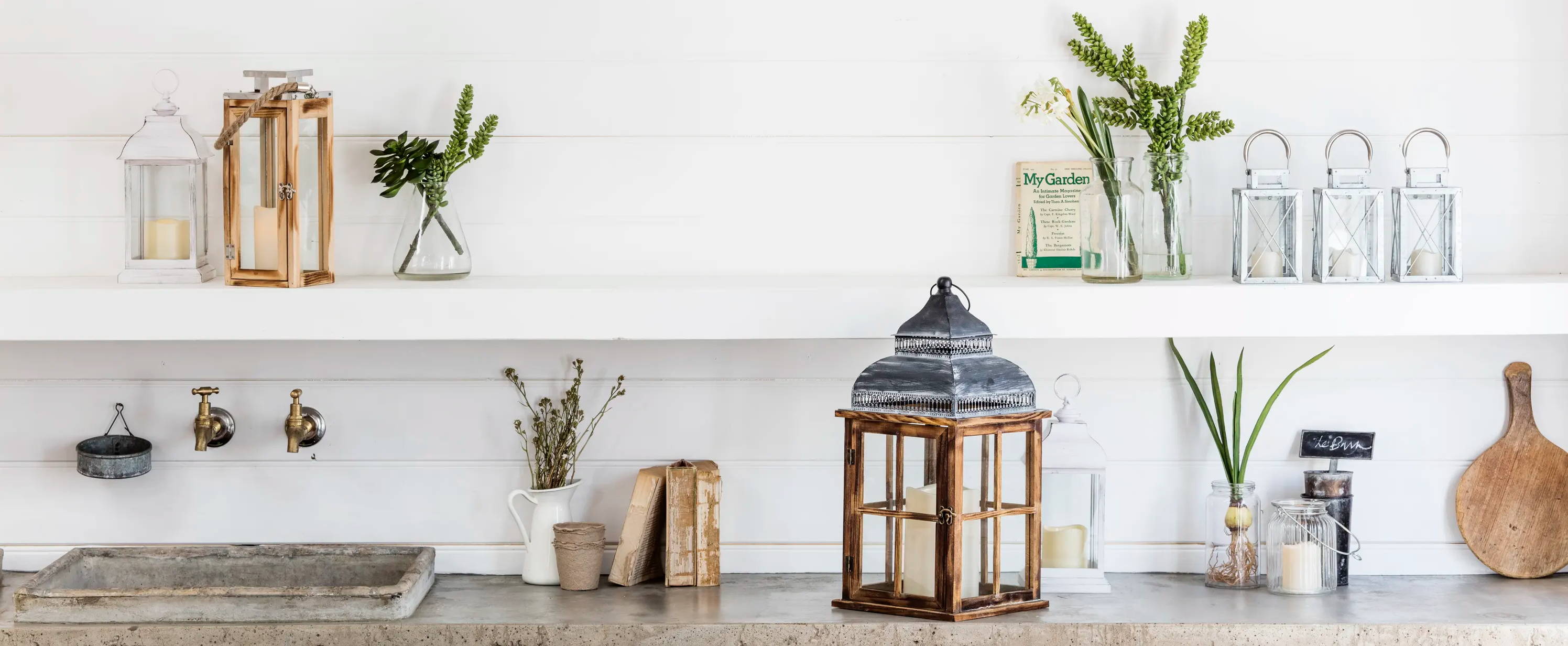 Kitchen decorated with candles, lanterns and sprigs of foliage.