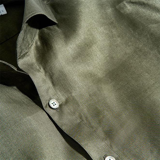 Close-up of an olive green shirt with buttons.