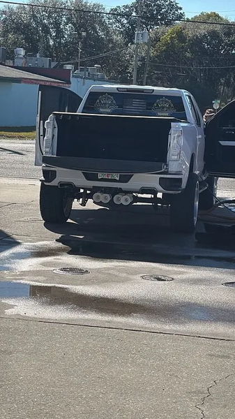 Rear view at car wash showing white horns under bumper on Joel's Silverado with tailgate down photo 4