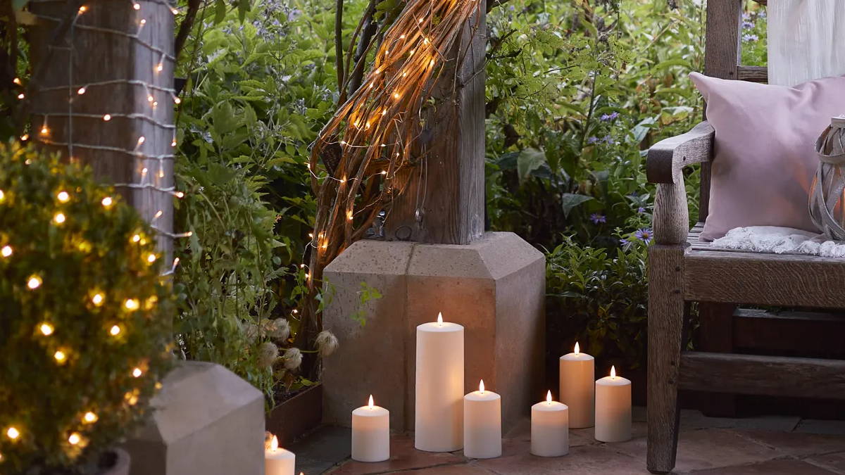 A garden patio setting with LED candles and fairy lights.