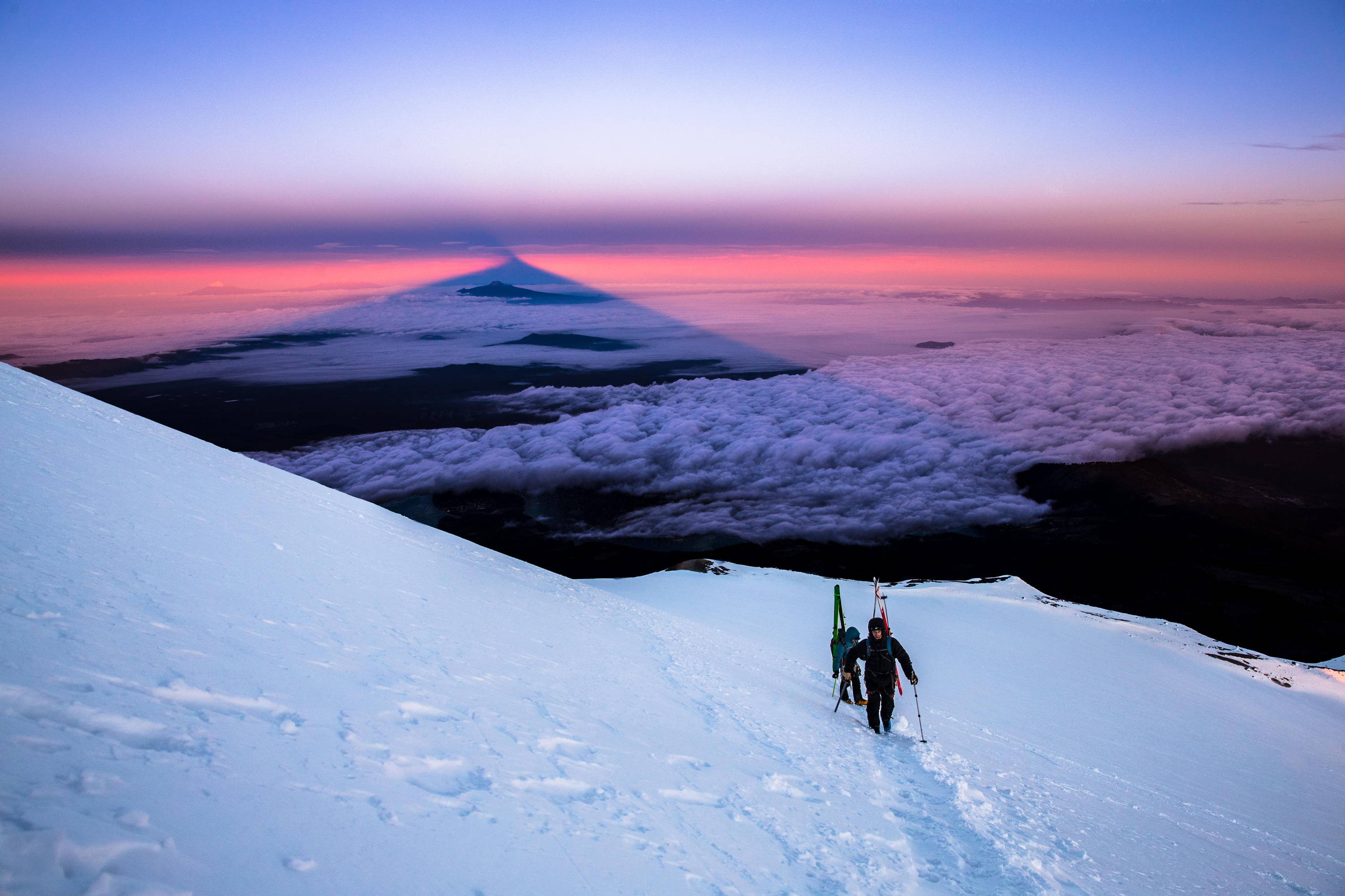 two skiers hiking a mountain