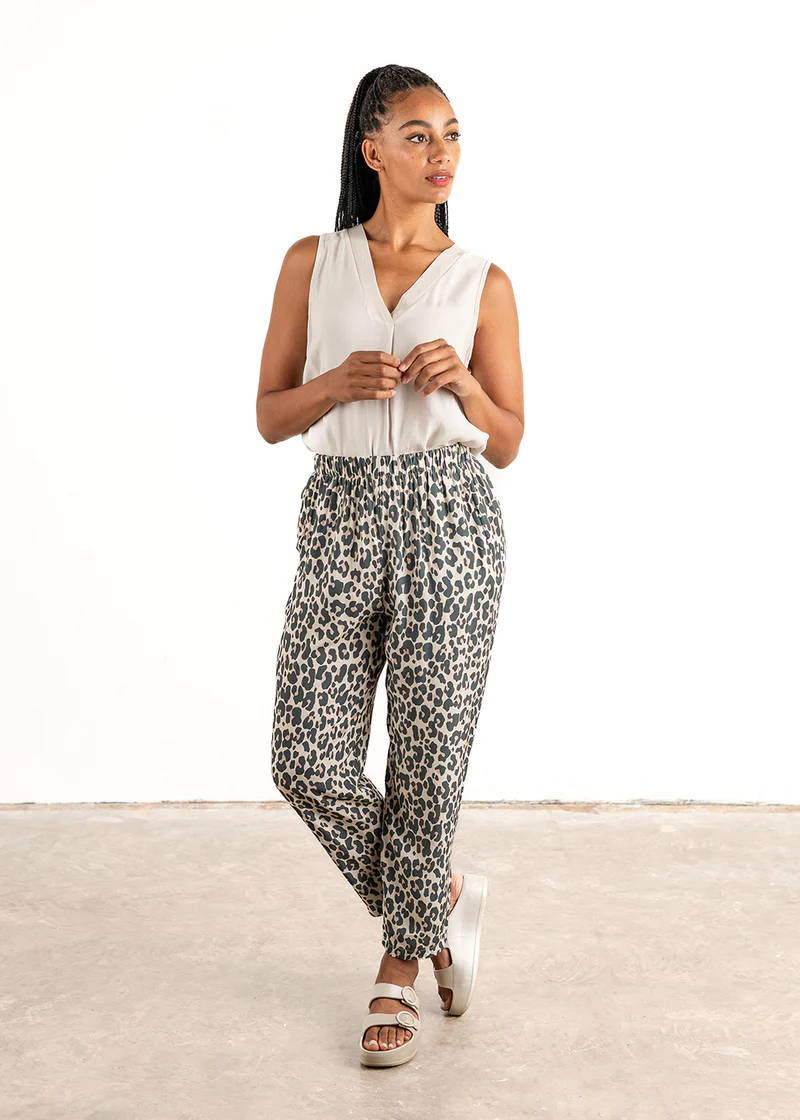 A model wearing an off white sleeveless tops with leopard print loose fitting trousers and off white chunky platform slides