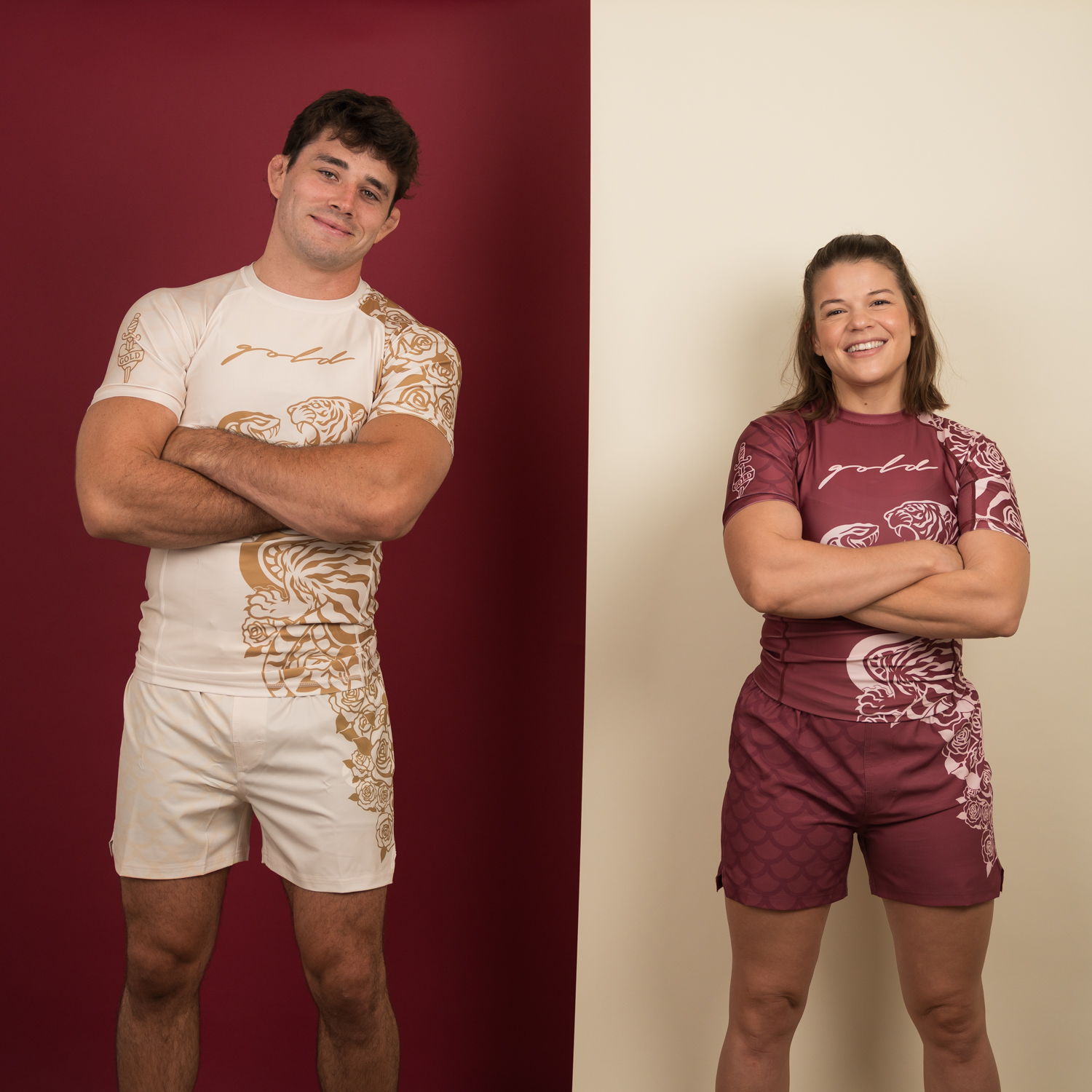 Two athletes in matching outfits, standing confidently with arms crossed.