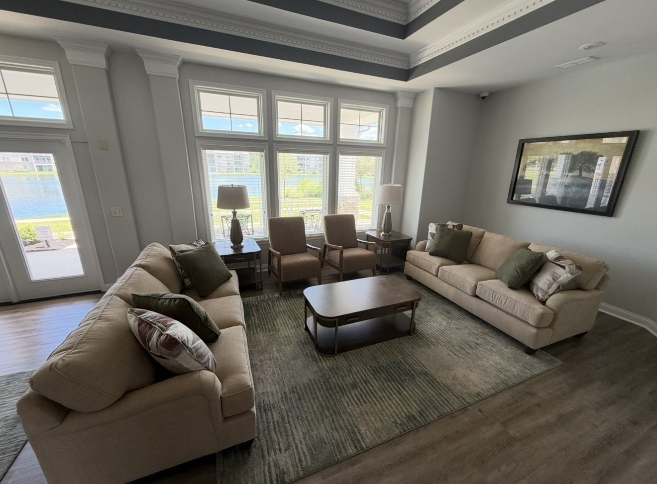 Living room with sofas, chairs, and large windows overlooking a scenic view.