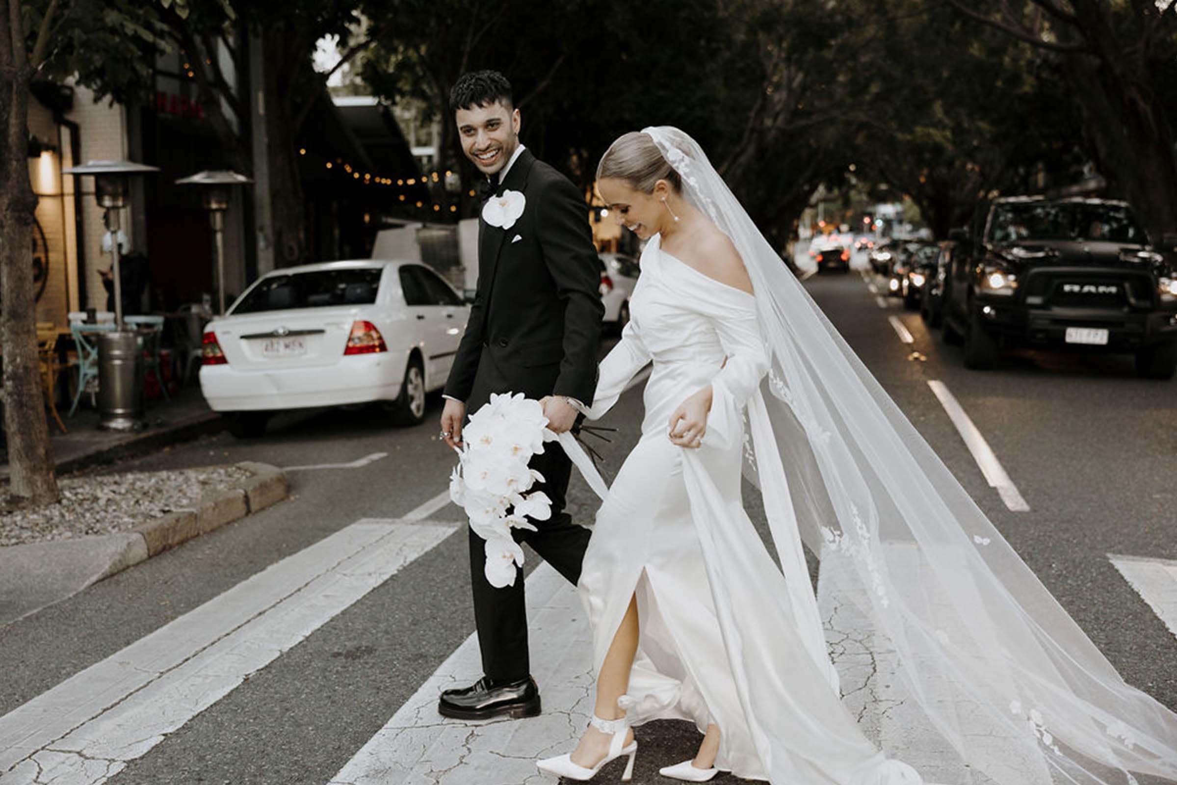 Bride and groom walking through city streets