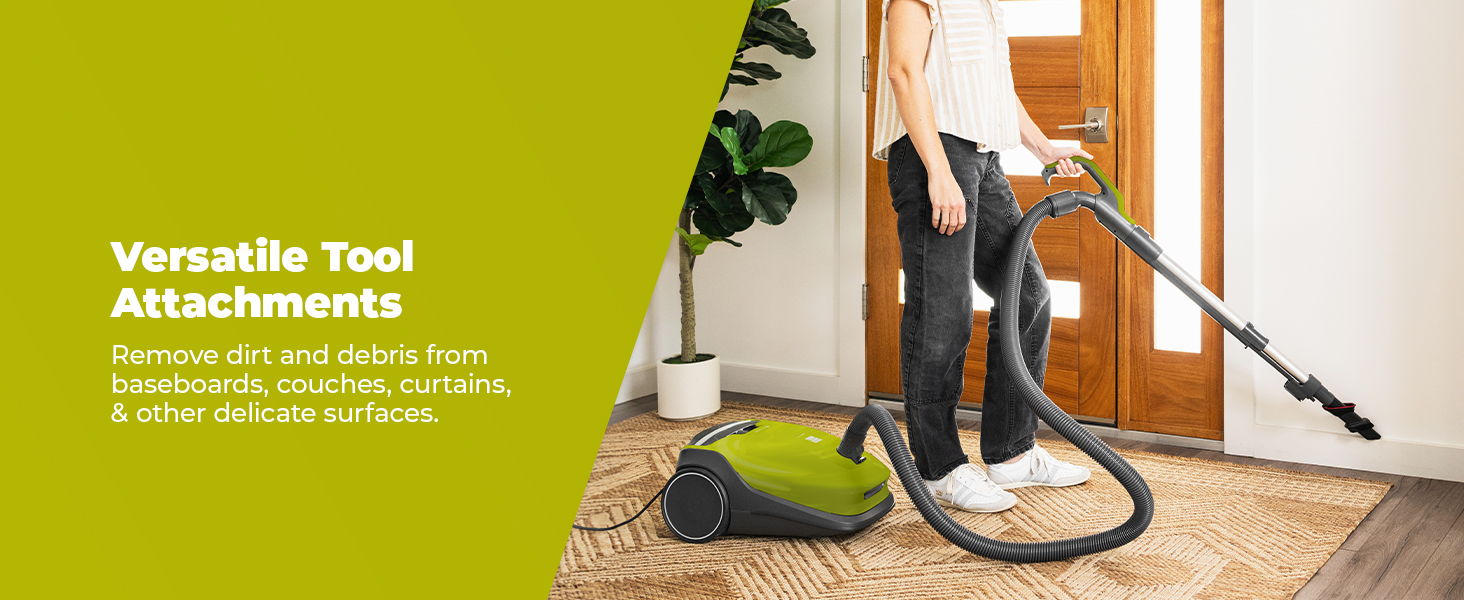 Person using a vacuum cleaner with various tool attachments in a home setting.