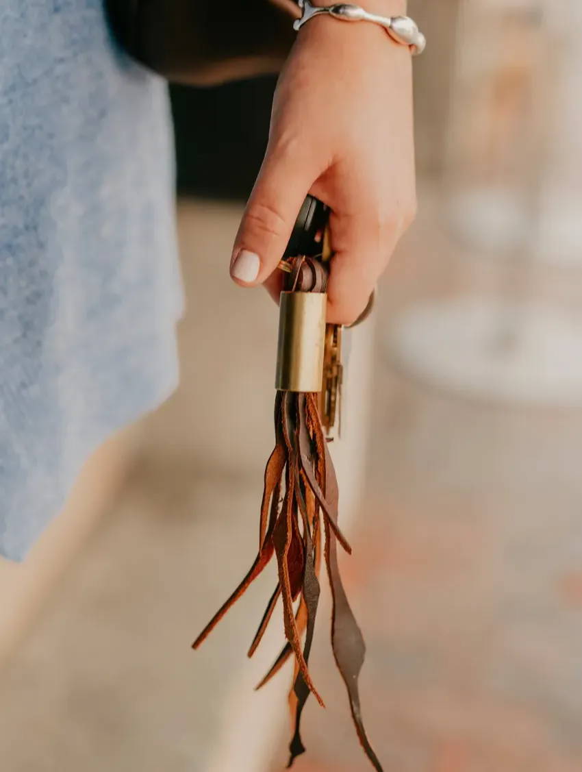 woman holding a tassel keychain