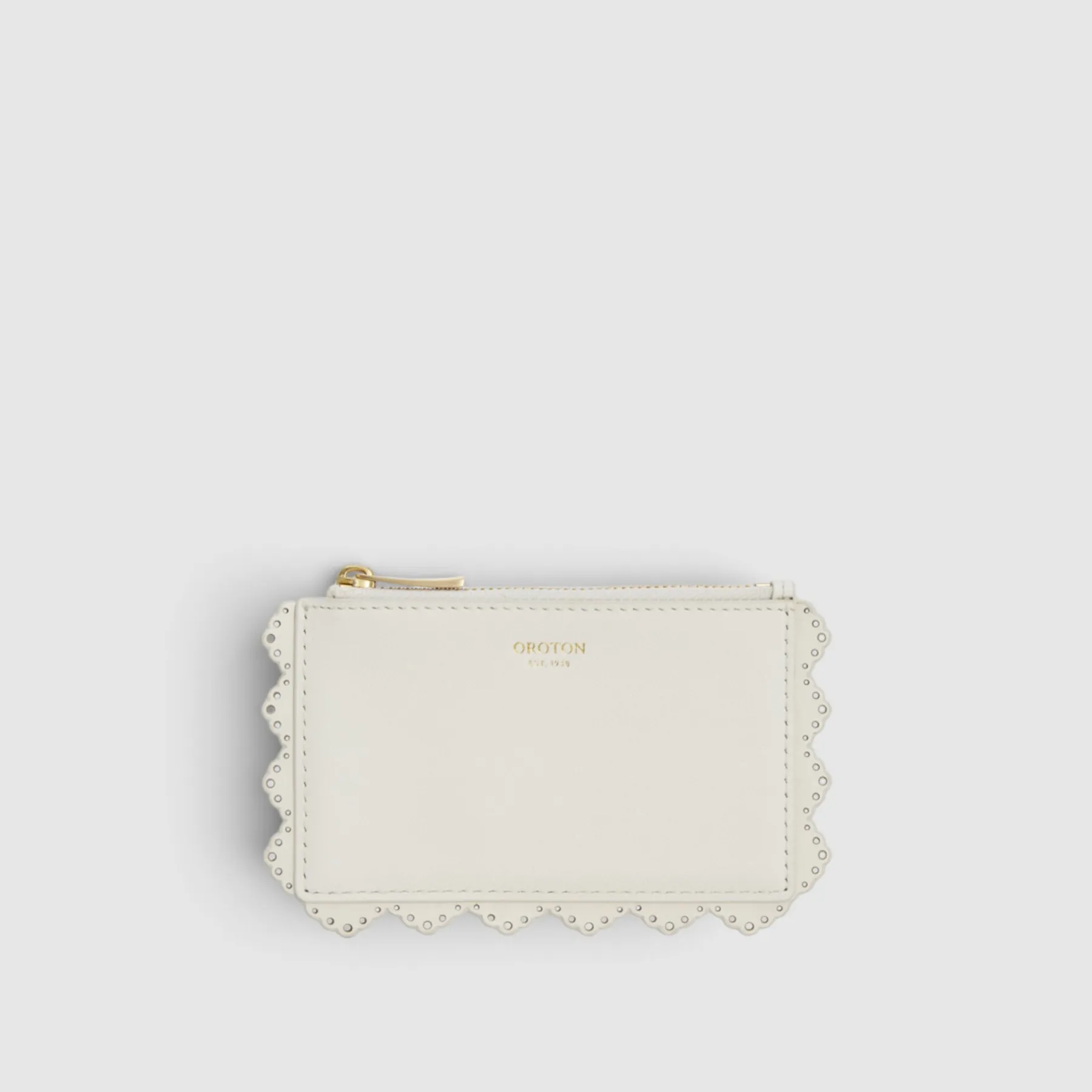White scalloped wallet with a zipper and gold accent.