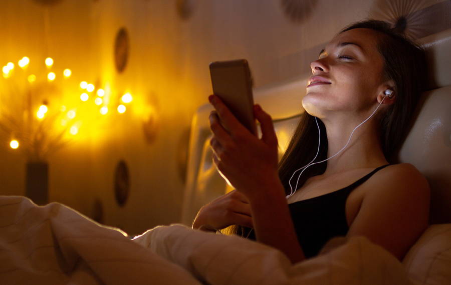 woman listening to music in bed
