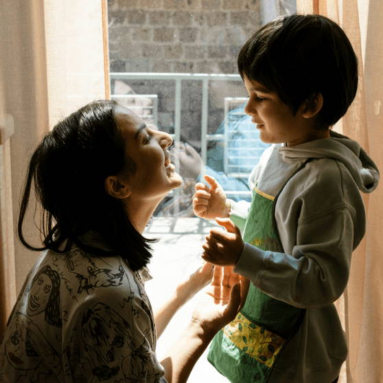 一名婦女與一名孩童在室內共享歡樂時光。