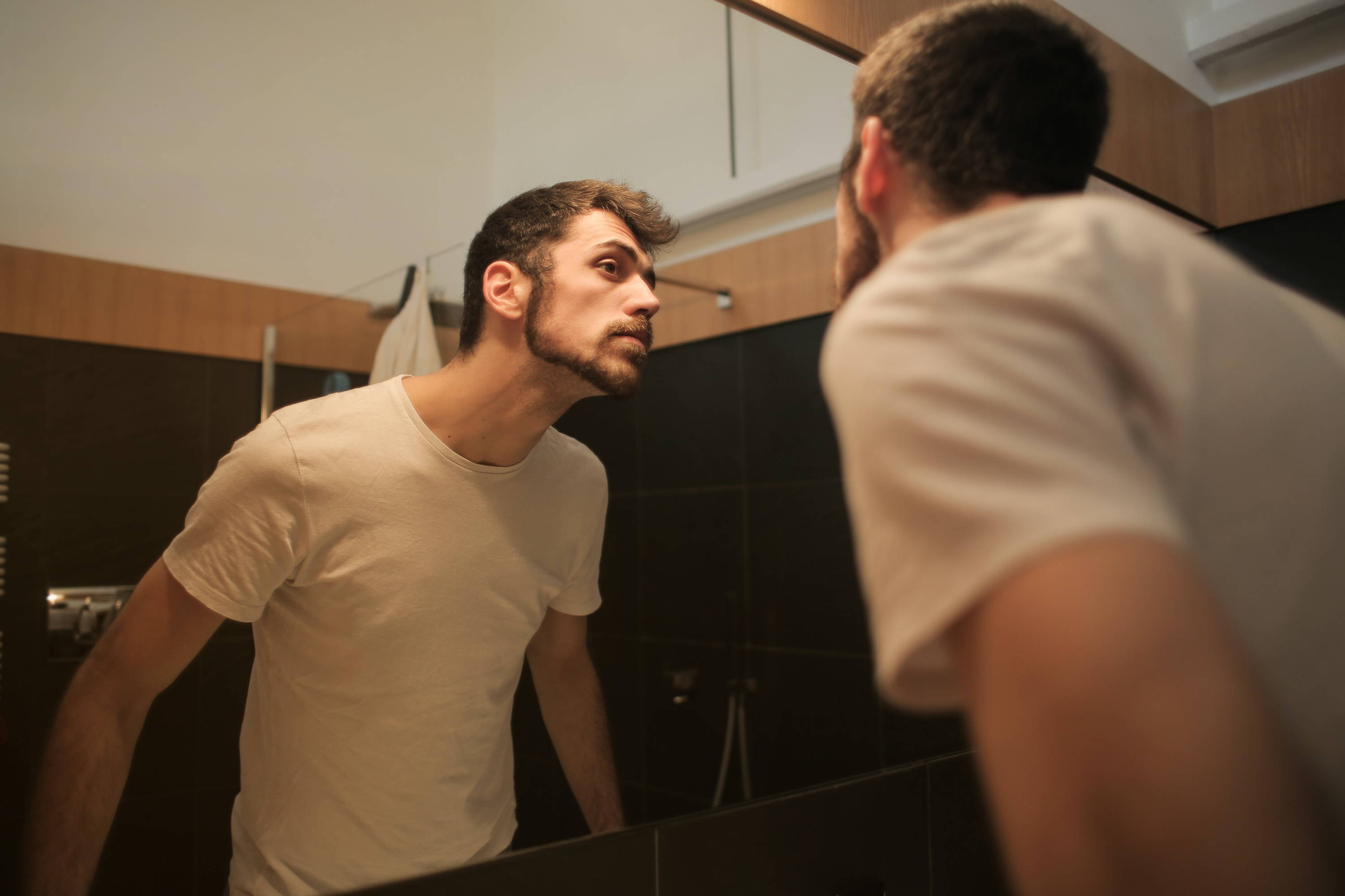 a man checking himself on the mirror after grooming
