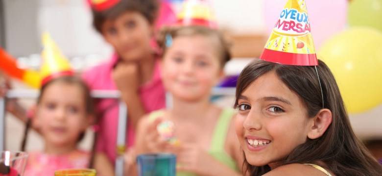 Image of kids at a party wearing party hats.