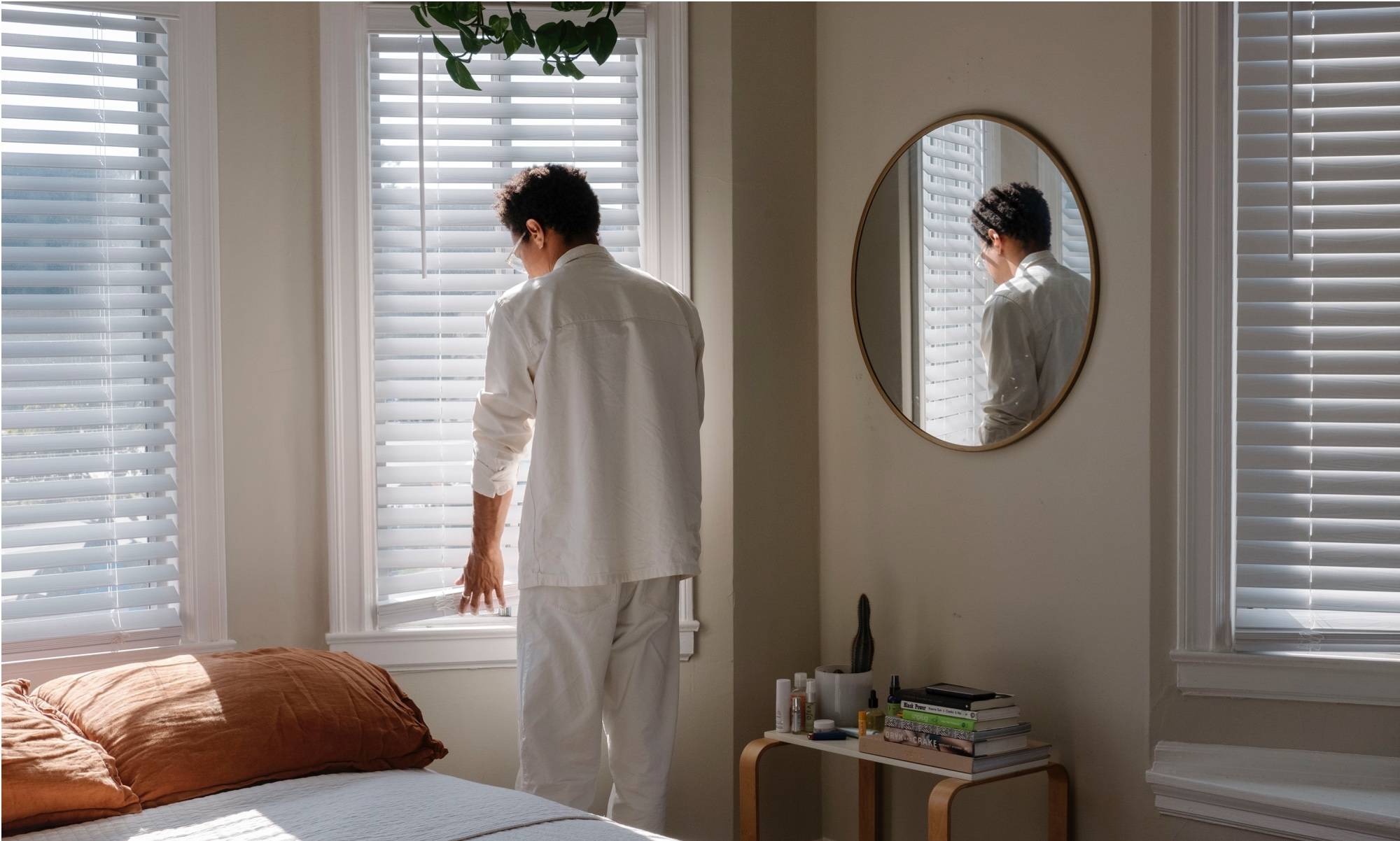 Richie at bedroom window next to queen Floyd platform bed & side table