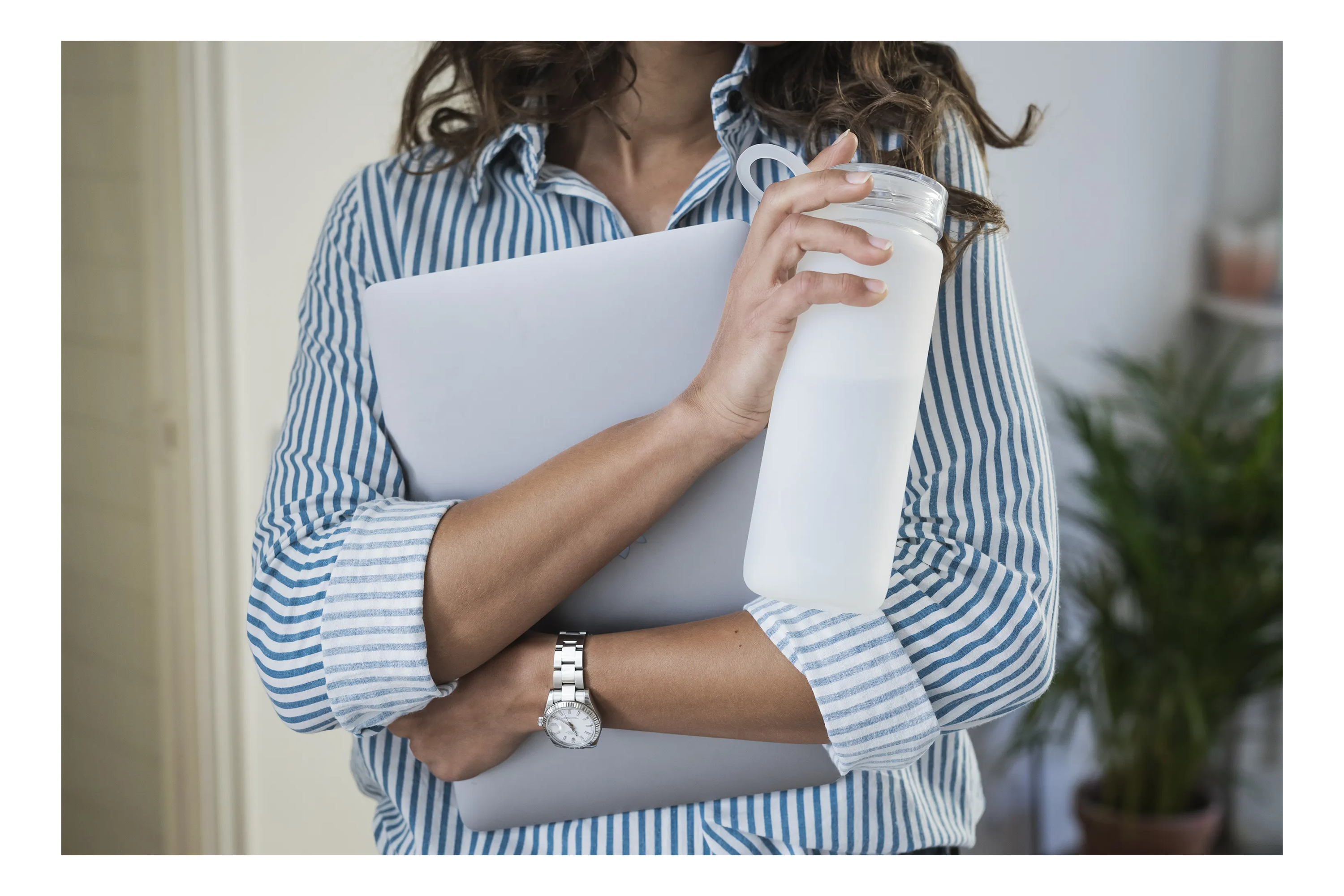 woman holding laptop and waterbottle
