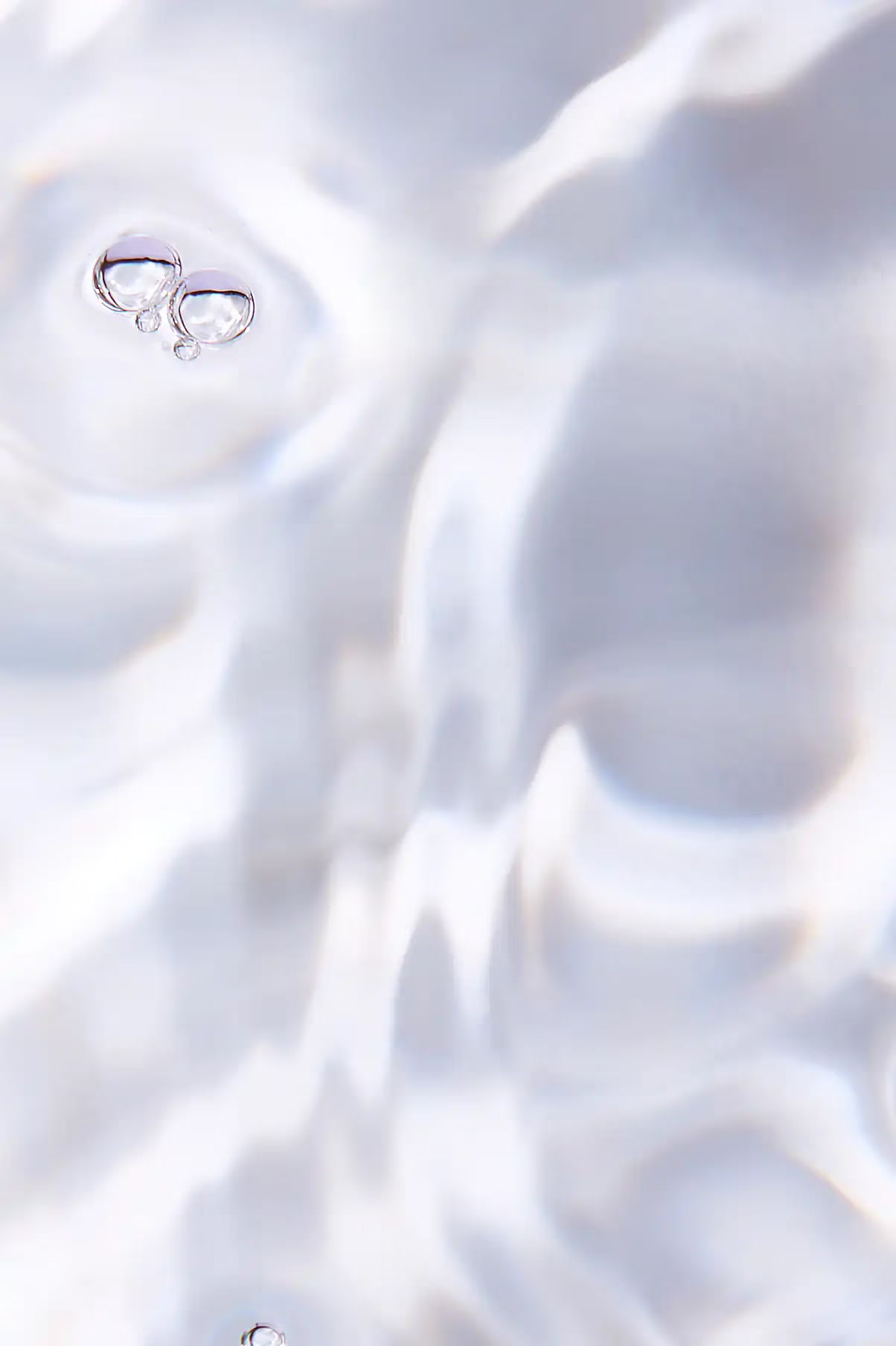 Close-up of rippling water with two small bubbles visible.