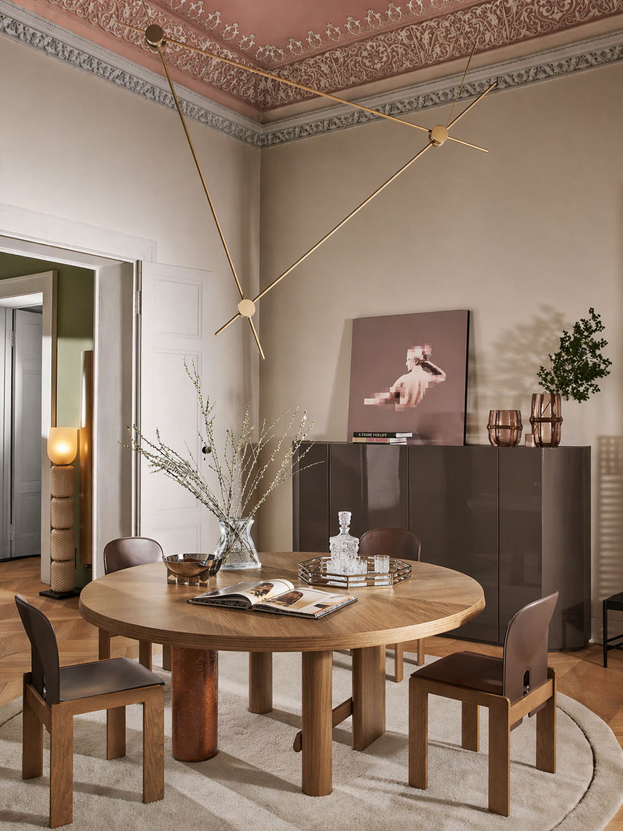 Modern dining room with a round table, chairs, and artistic decor.