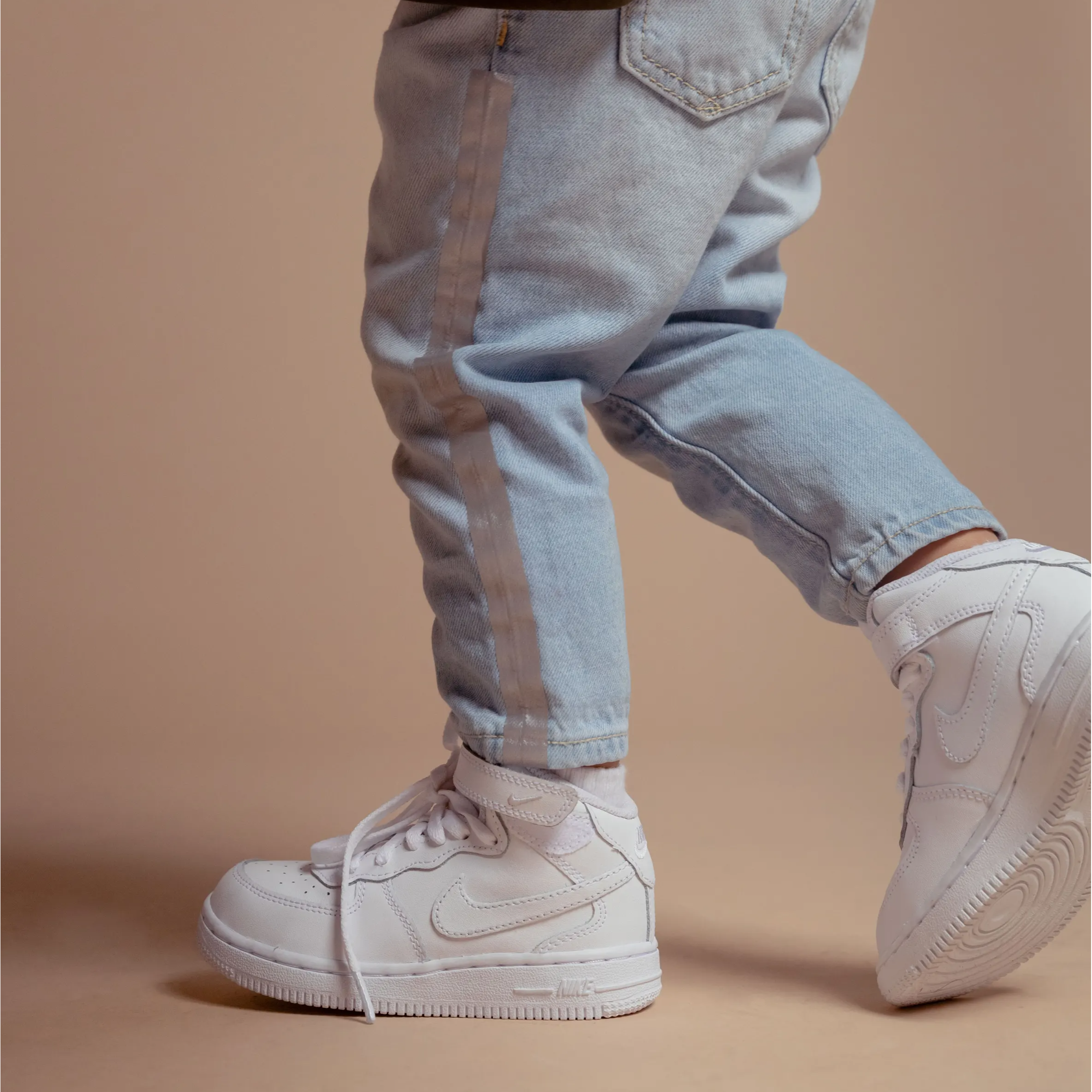 white nike air force ones on child's feet