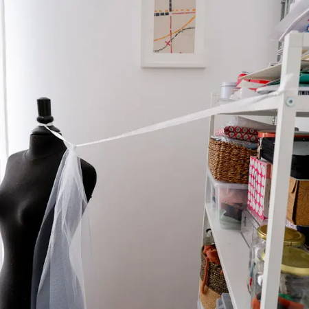 The ribbon for the waist attached to a mannequin and a book shelf