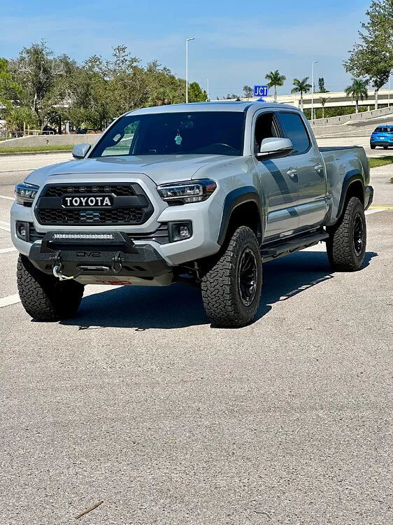 Front three-quarter cement gray Tacoma heritage grille DV8 bumper lift KO2 tires rock sliders Bruce's 2019 Tacoma Stealth gallery photo 2