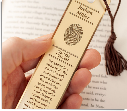 brass bookmark engraved with a fingerprint, name, dates, and inscription