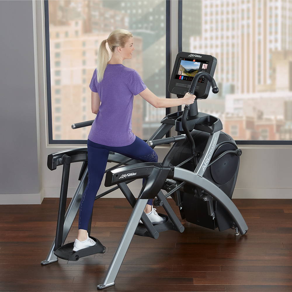 Female exercising on Life Fitness Arc Trainer in home overlooking city