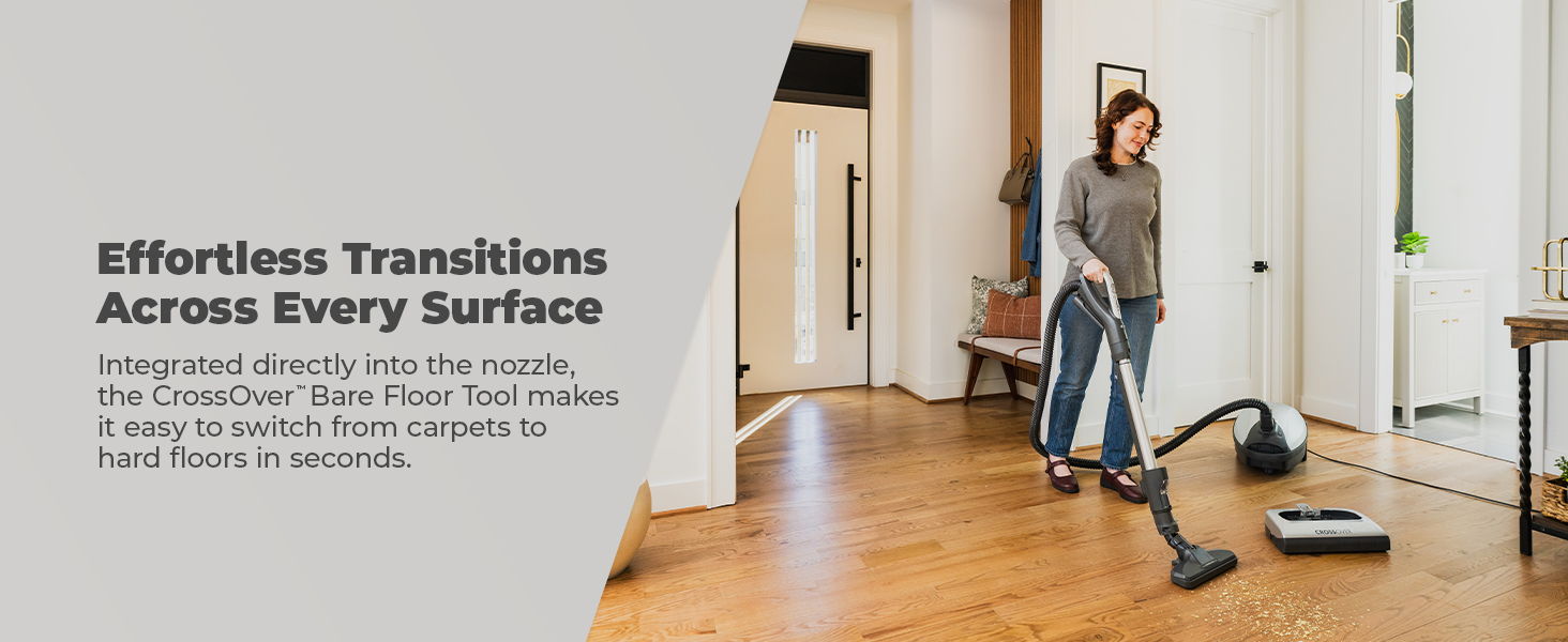 Woman vacuuming a room with wooden floors and a light-colored rug.