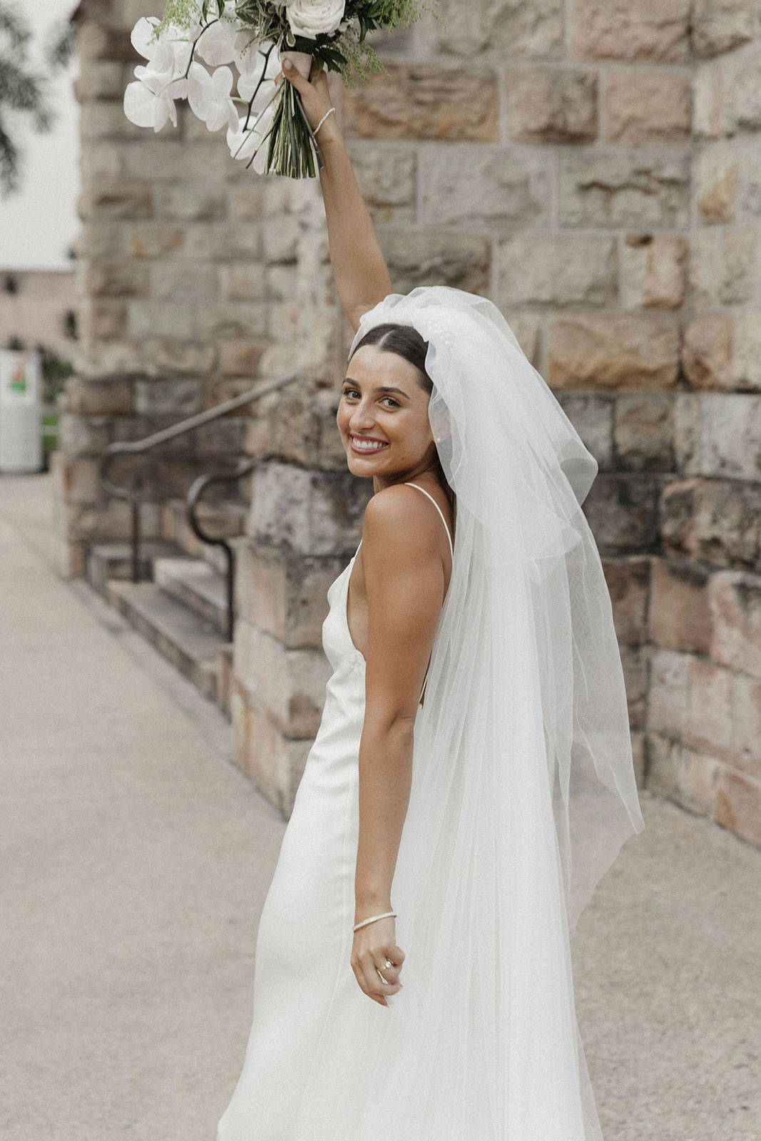 La mariée soulevant son bouquet