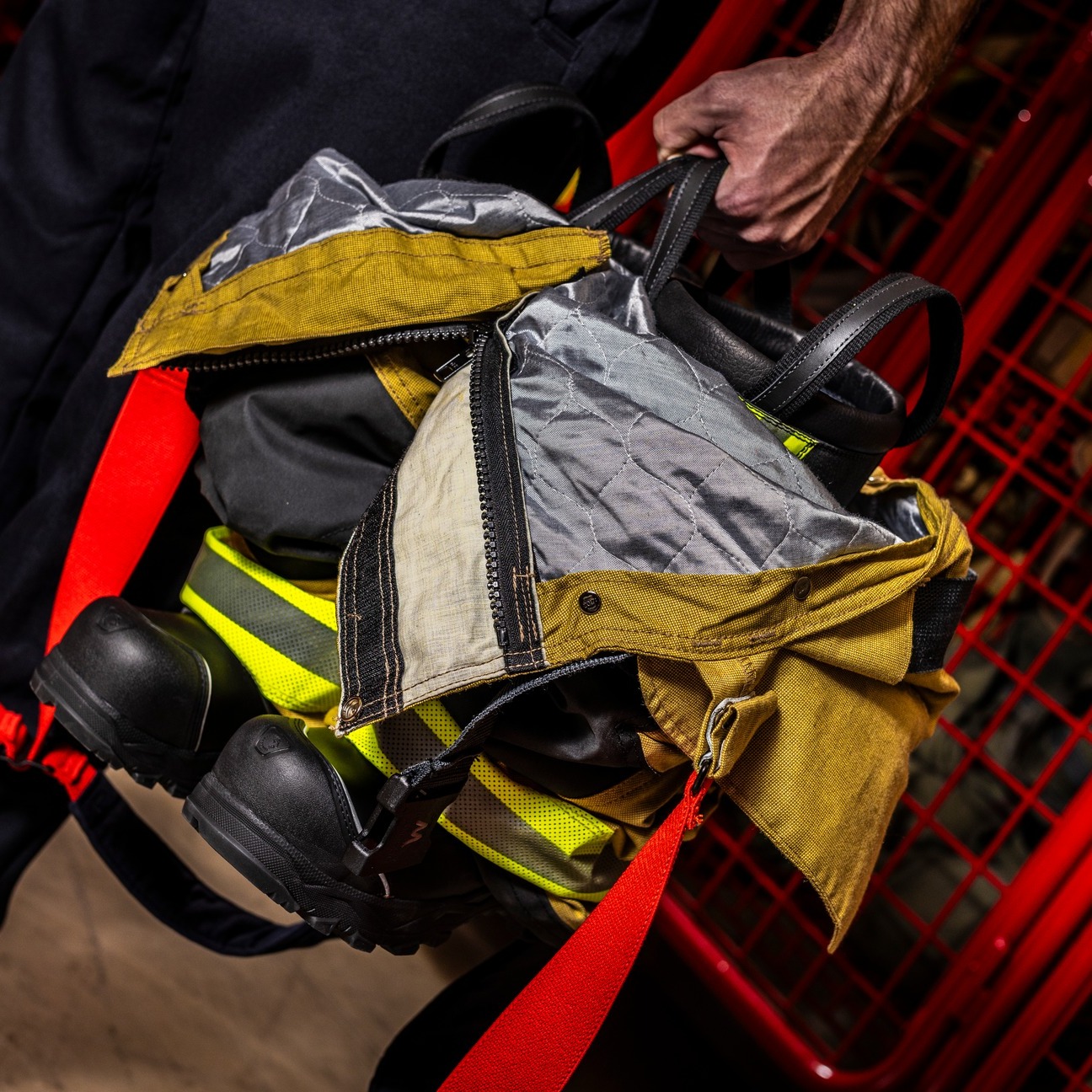 Firefighter gear being carried, including helmet and oxygen tank.