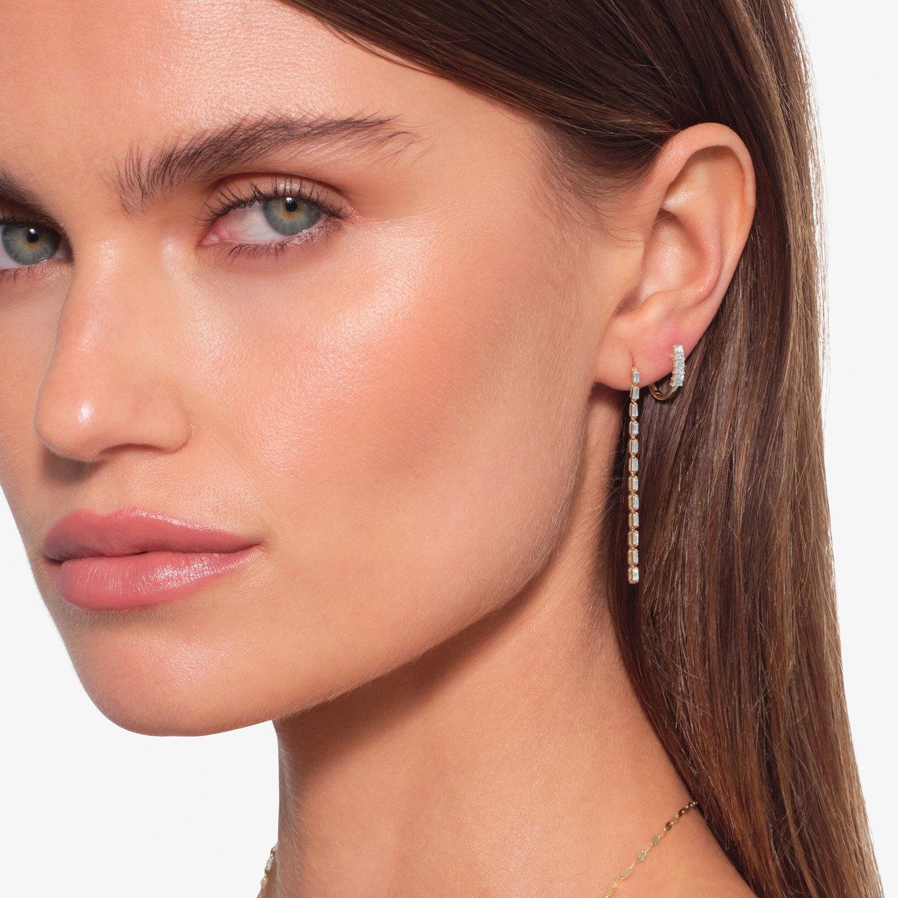 Close-up of a woman with long hair and dangling earrings.