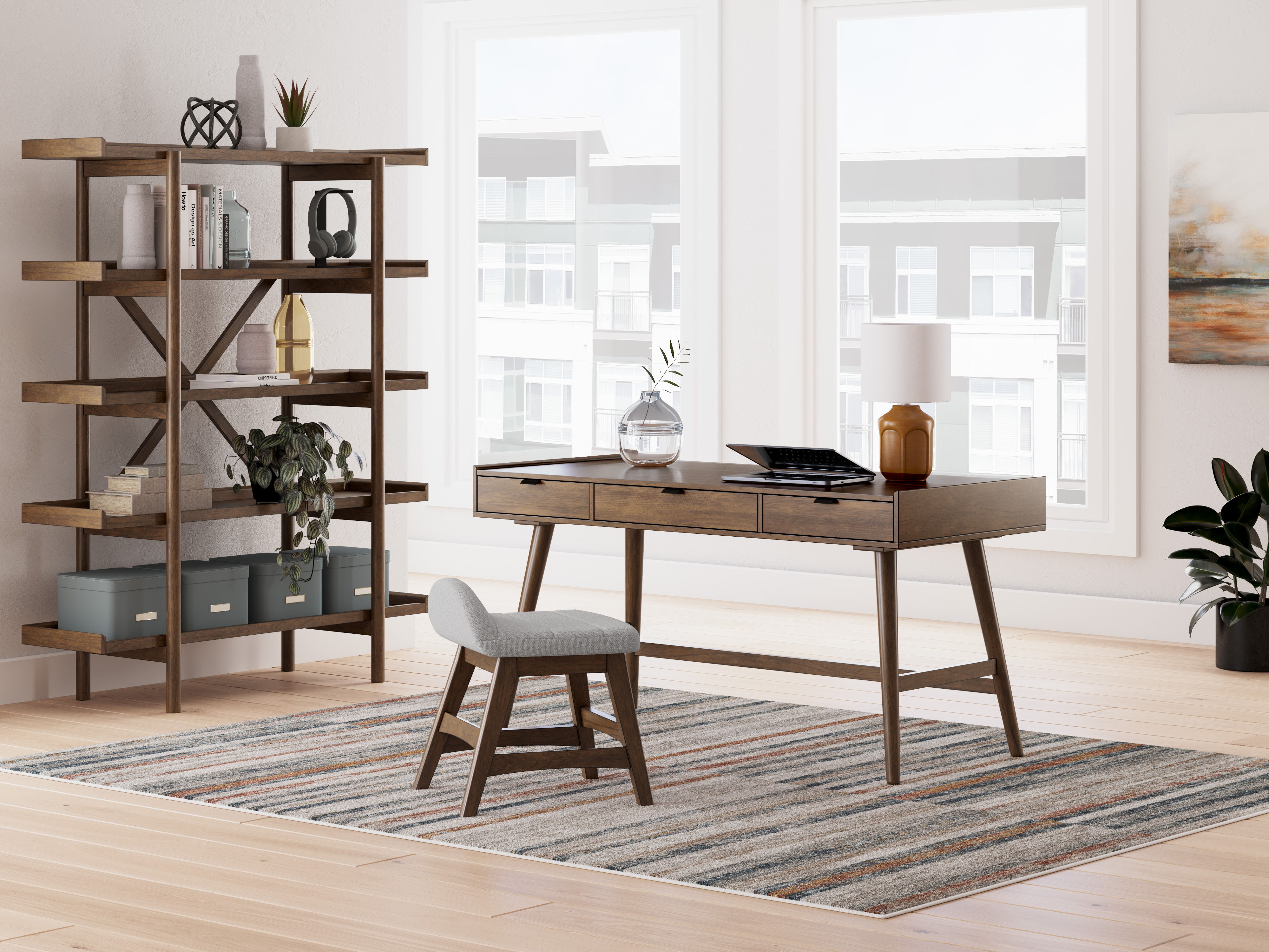 A modern home office with a desk, chair, and bookshelf.