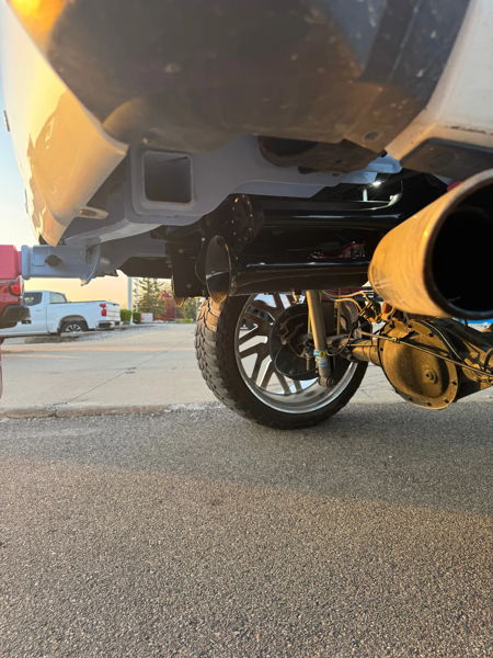 Low-angle rear undercarriage showing train horns and Bilstein shock on Brianna's Silverado photo 2