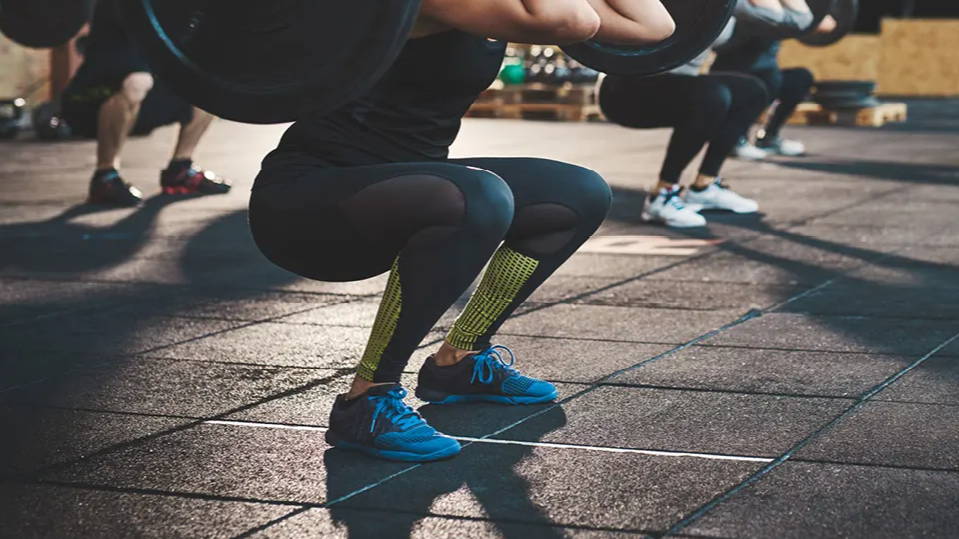 Woman squatting while holding heavy weights inside a gym