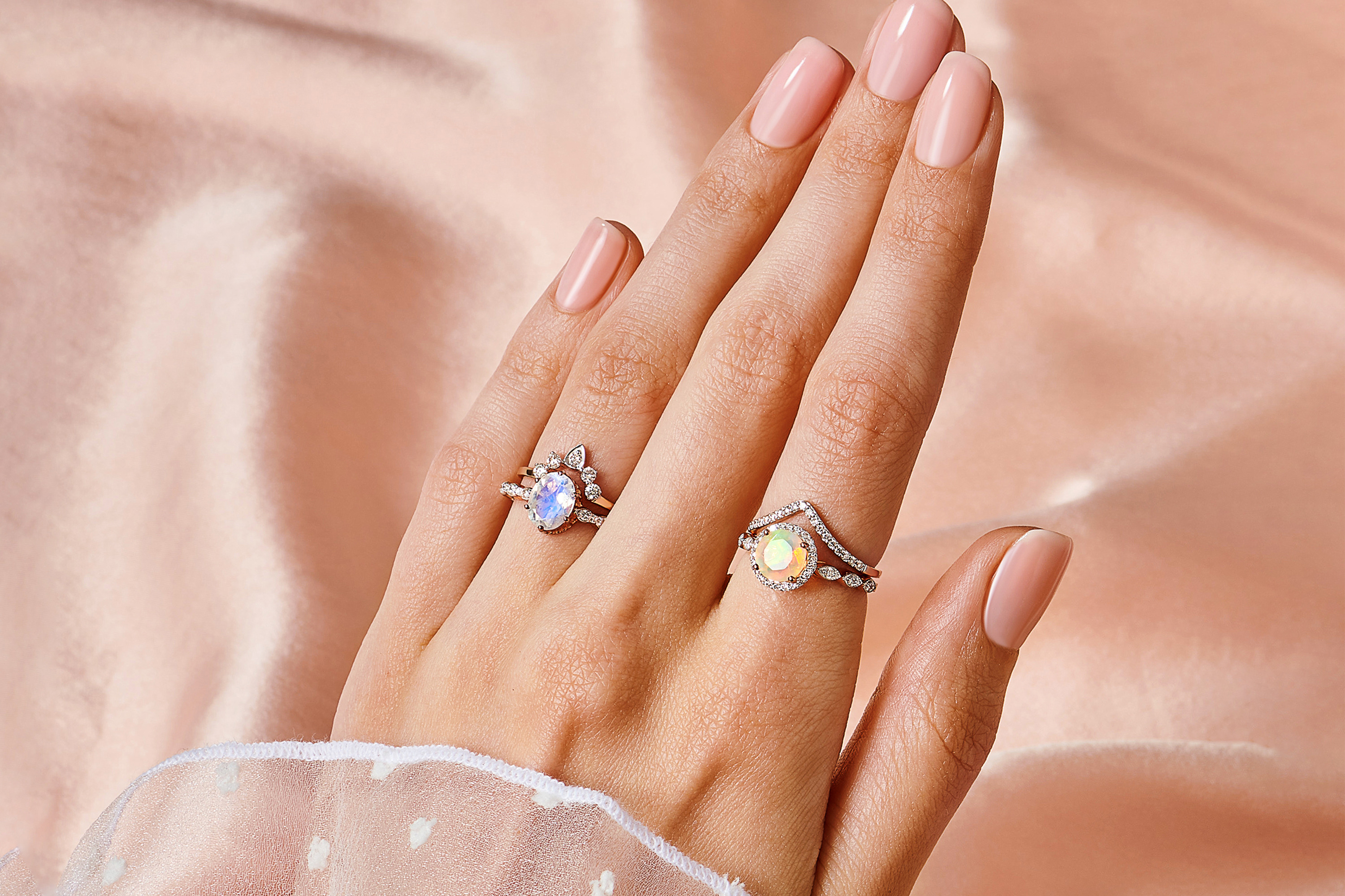 A woman is wearing Opal Diamond Ring - Soulmate paired with Diamond Ring - Bonding Arc and Moonstone Ring with Diamonds - Mirth paired with Diamond Ring - Vow.