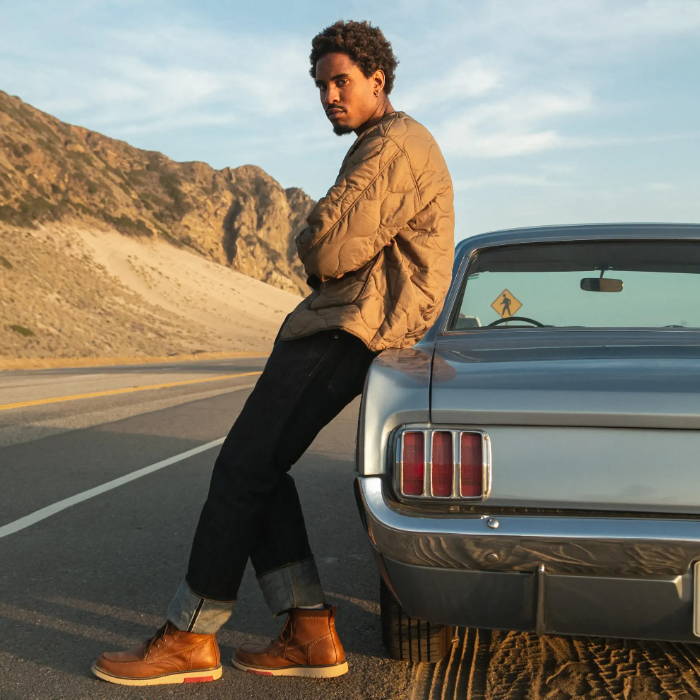 man leaning on vintage car wearing levi's boots