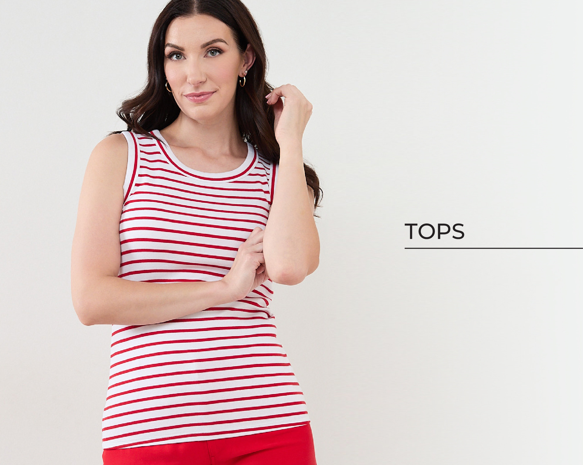Woman in a striped tank top against a light background, showcasing a fashion item.