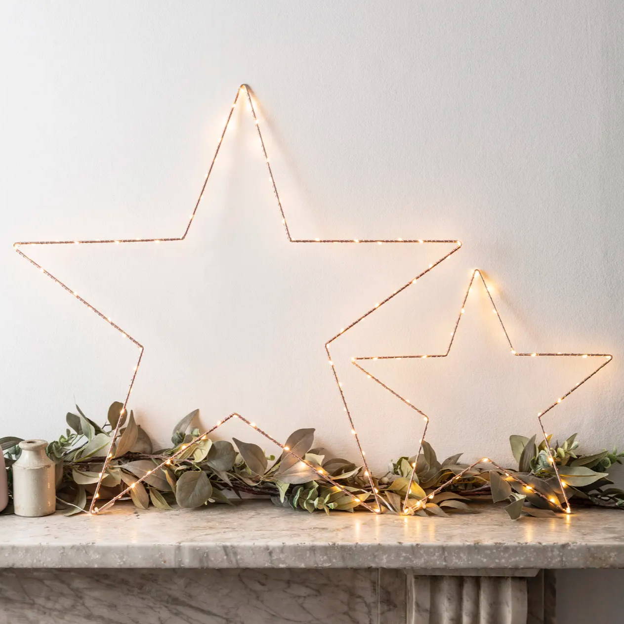 Two Osby star led lights resting on top of a mantle