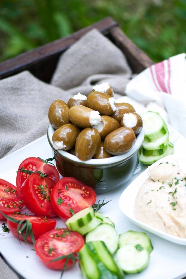 Feta stuffed olives served with tomatoes, cucumbers and hummus