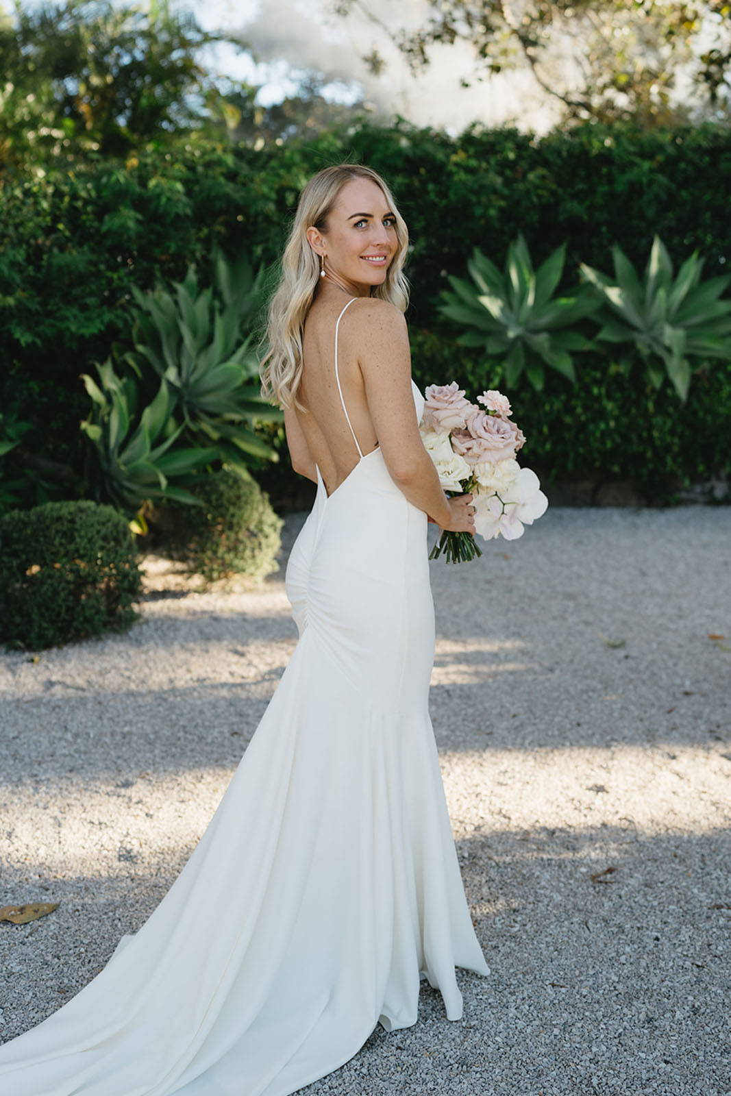 Bride, walking outside and holding her bouquet toss