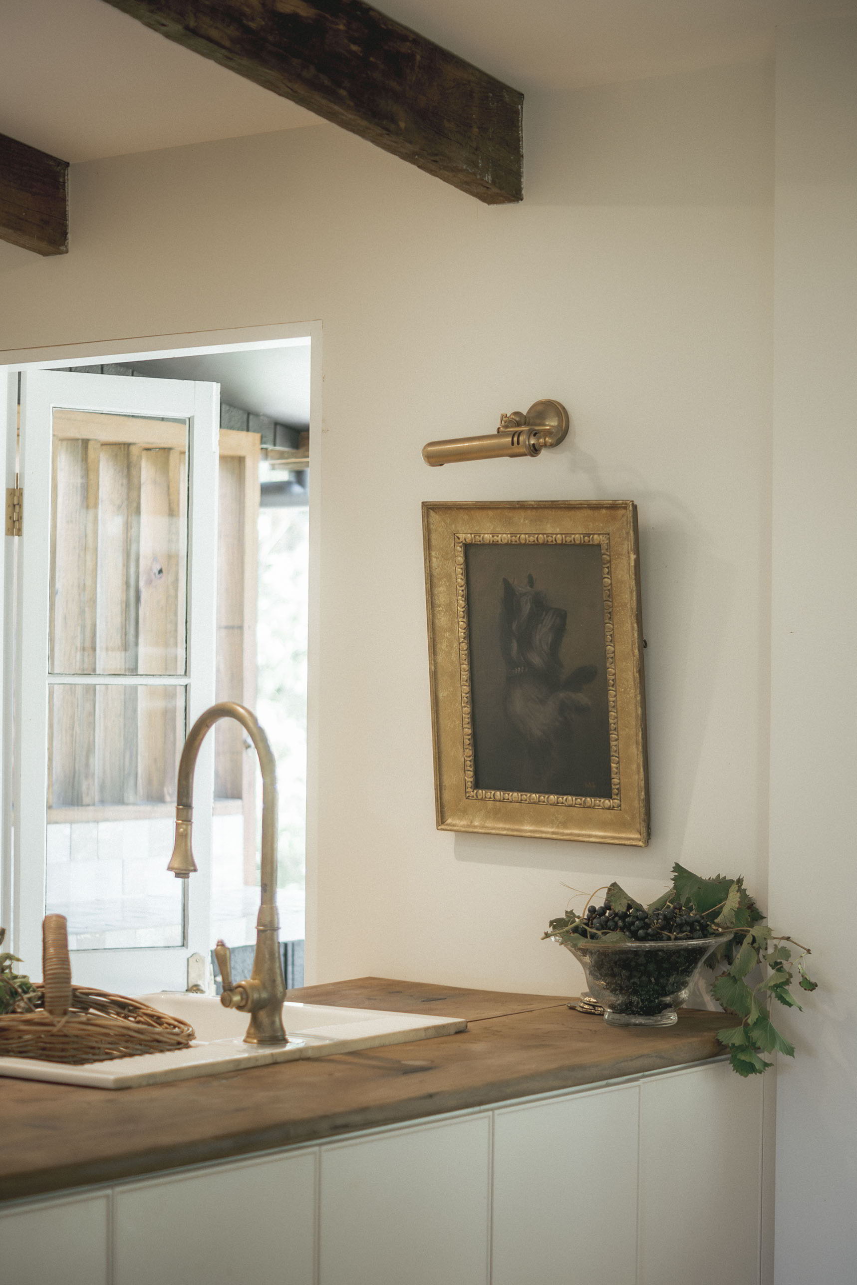 A modern kitchen with a wooden countertop and framed artwork on the wall.