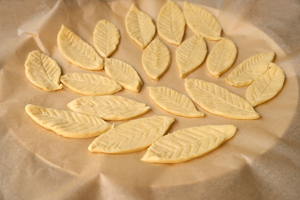 Leaf-shaped pastry arranged on parchment paper.