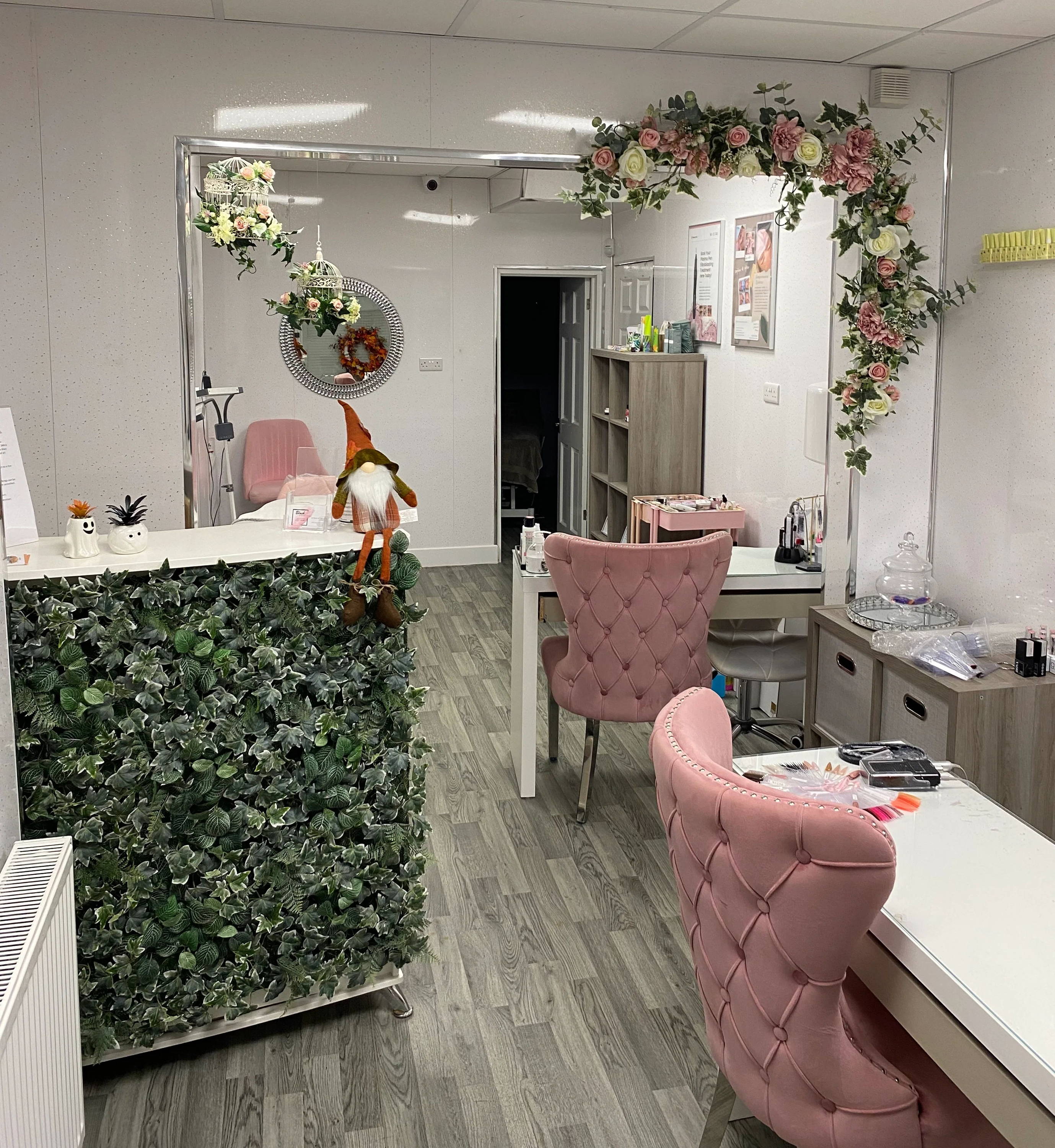 Interior of a stylish office with greenery and pink decor.