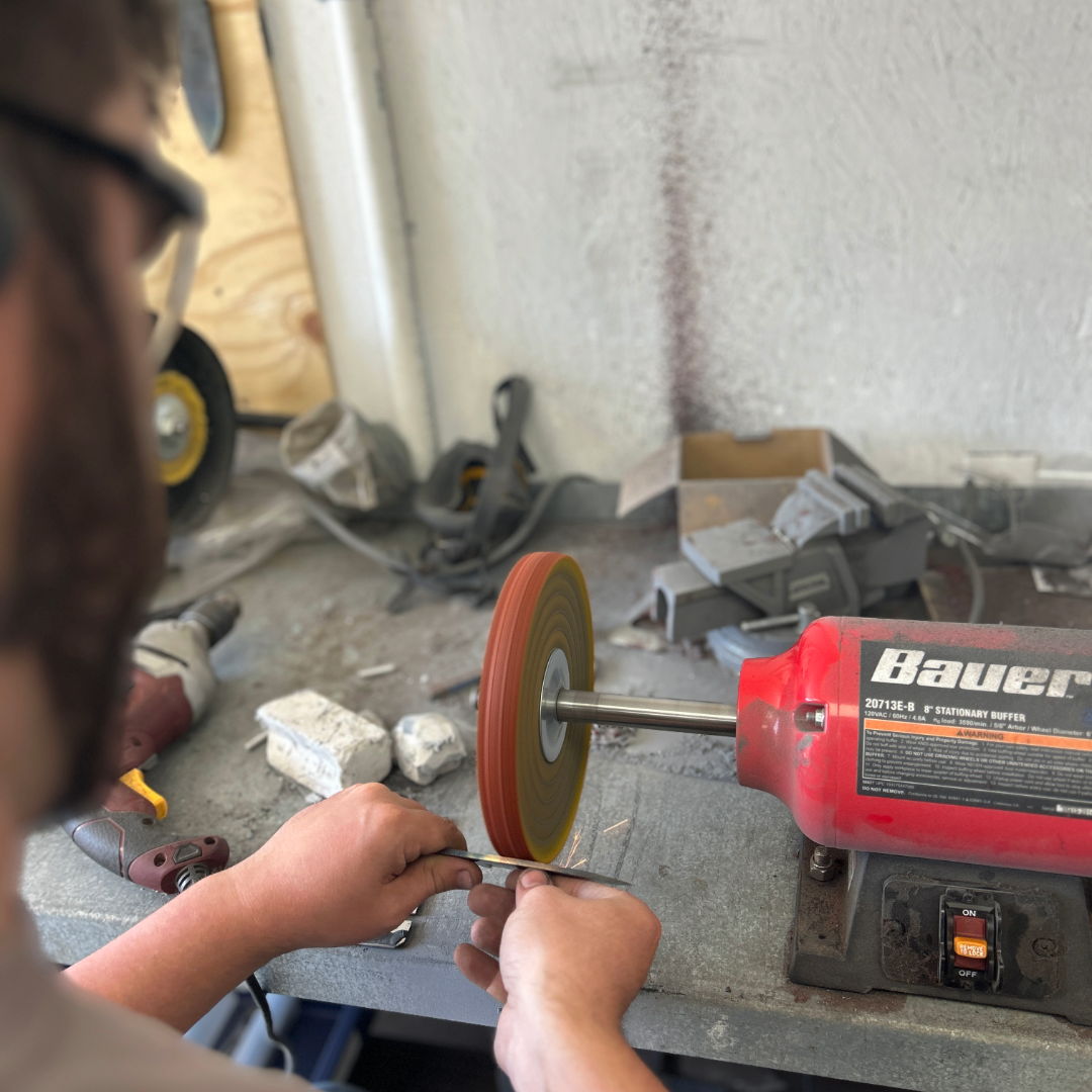 Person using a grinder tool in a workshop setting.