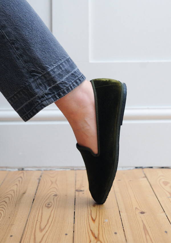 A styled image of a model foot on point wearing the Drogheria Crivellini Velvet Venetian Loafers in olive.