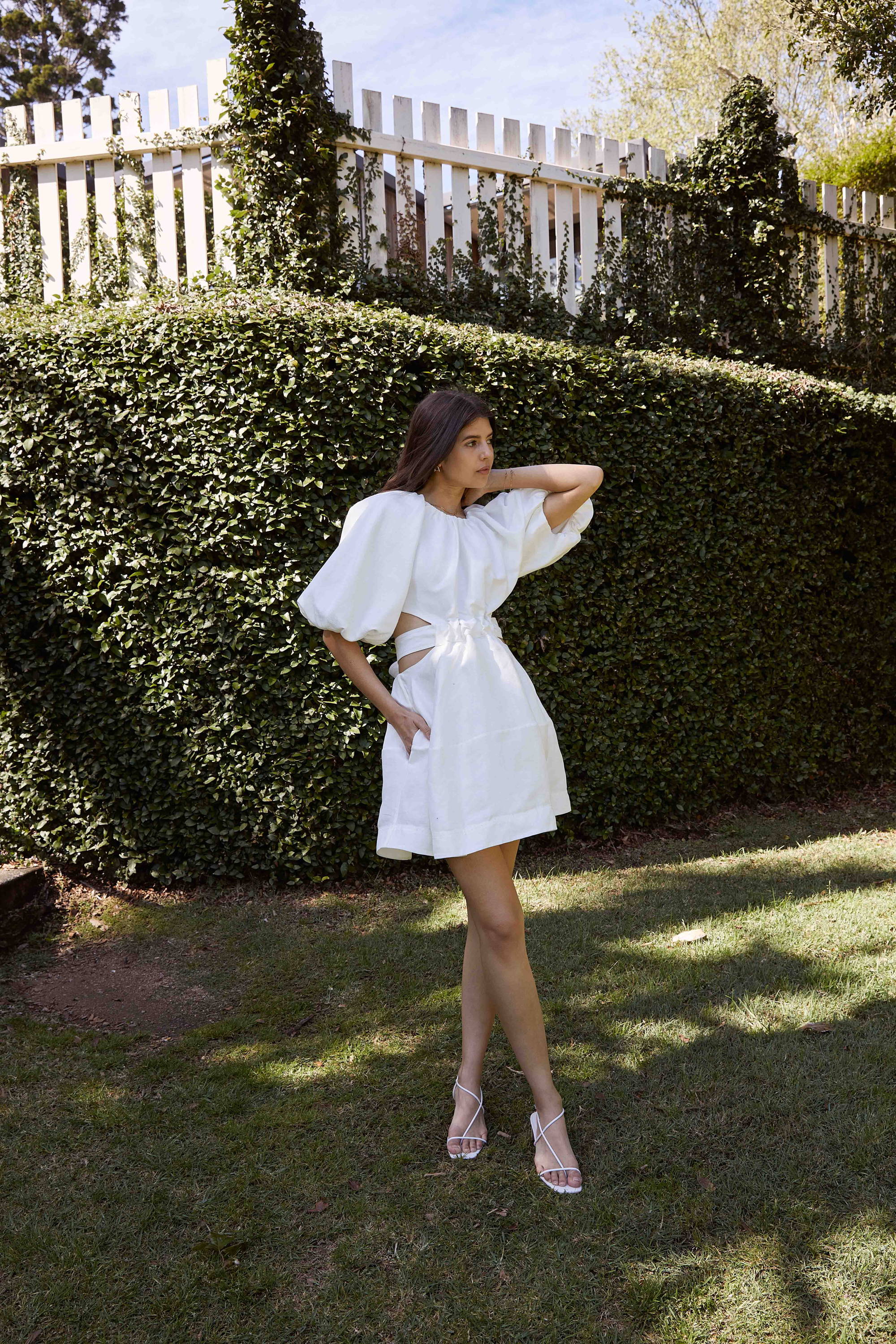 Talisa Sutton wears an Aje white mini dress in the garden.