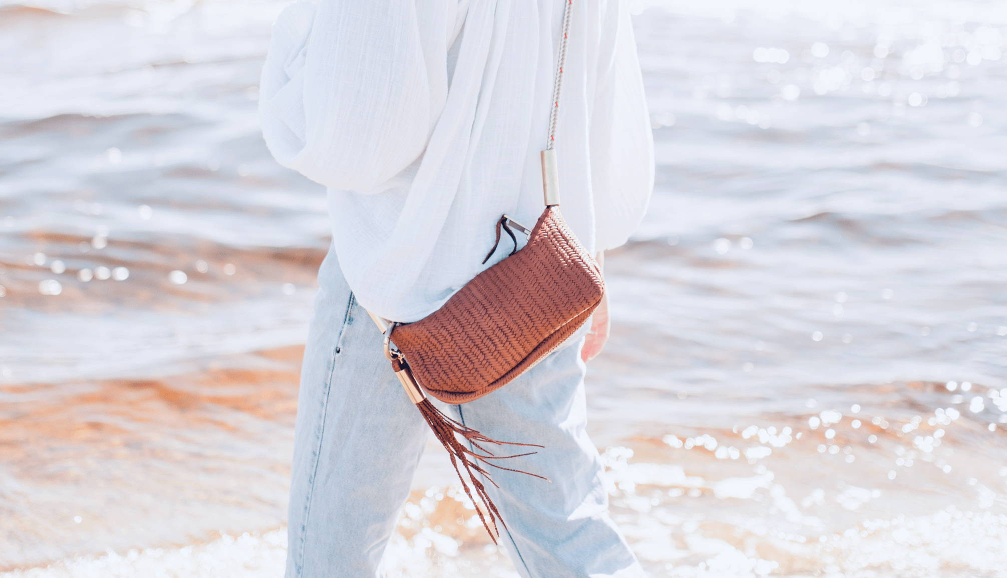 woman in the water with a basketweave leather crossbody bag