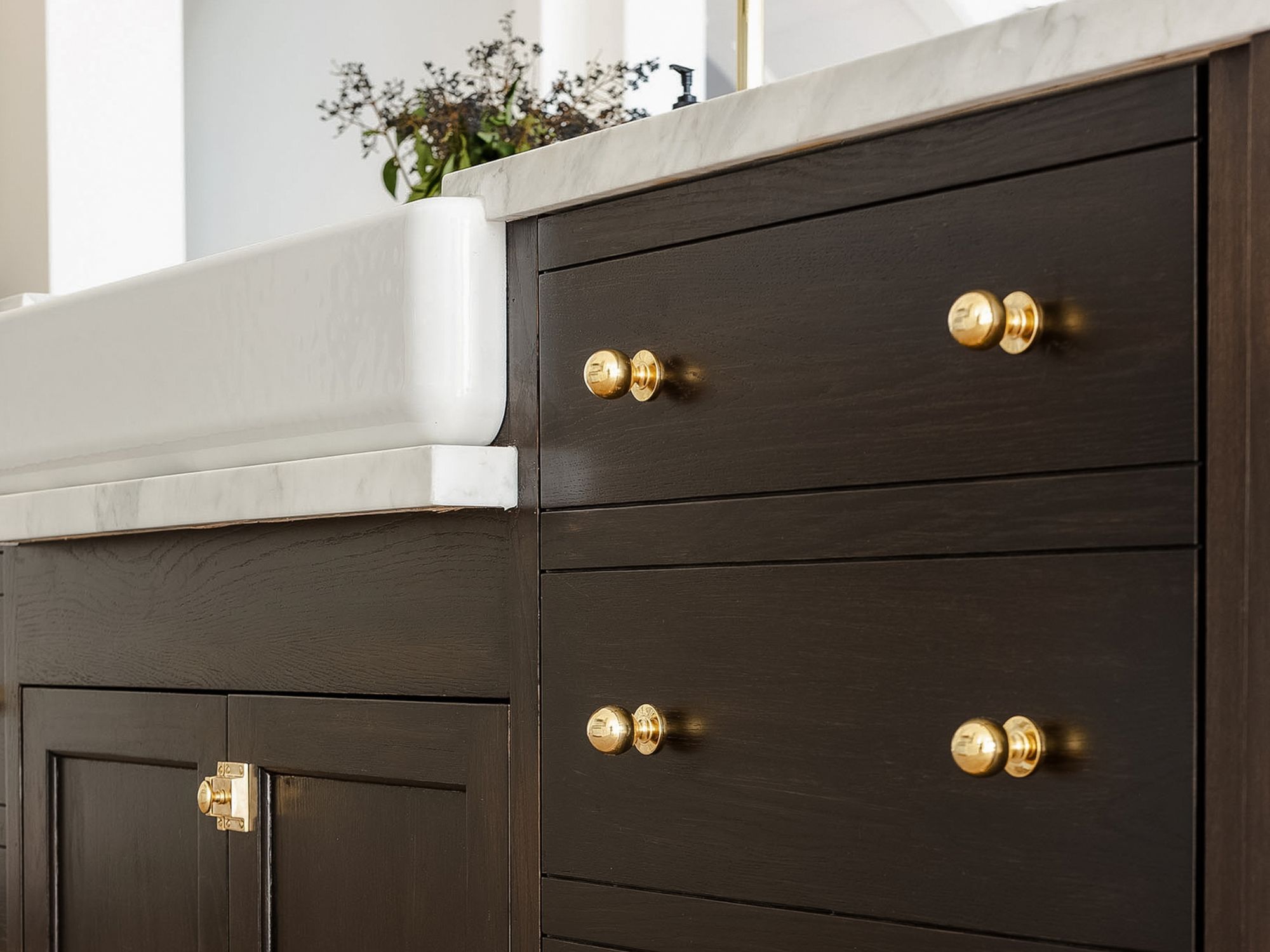 studio mcgee kitchen brass hardware on dark wood cabinets