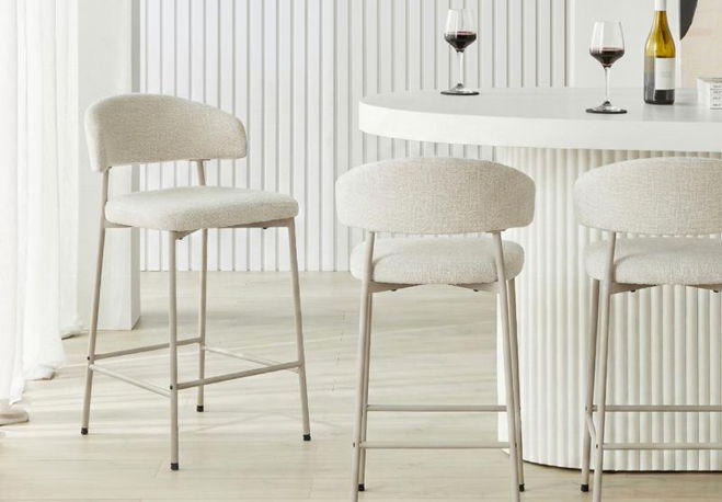 Three modern bar stools in a bright, contemporary setting with wine glasses.